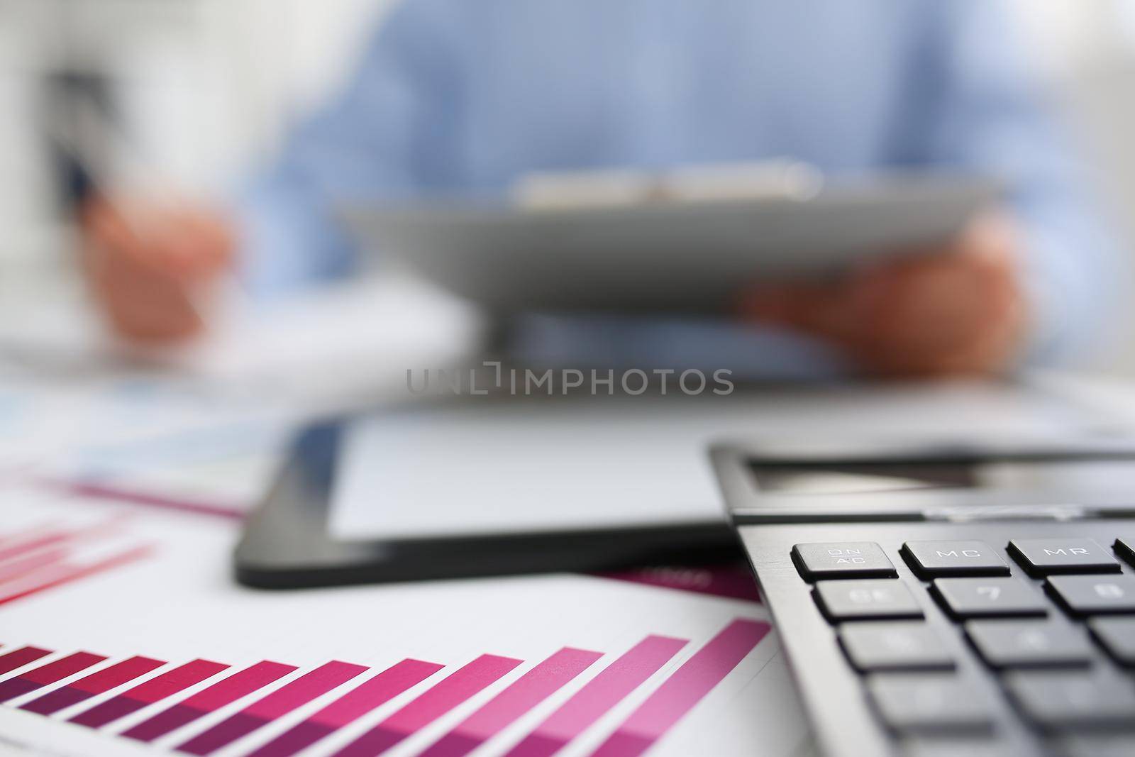 Black calculator and financial statistics on clipboard pad at office table closeup. Internal Revenue Service inspector sum check irs investigation earnings savings loan and credit concept