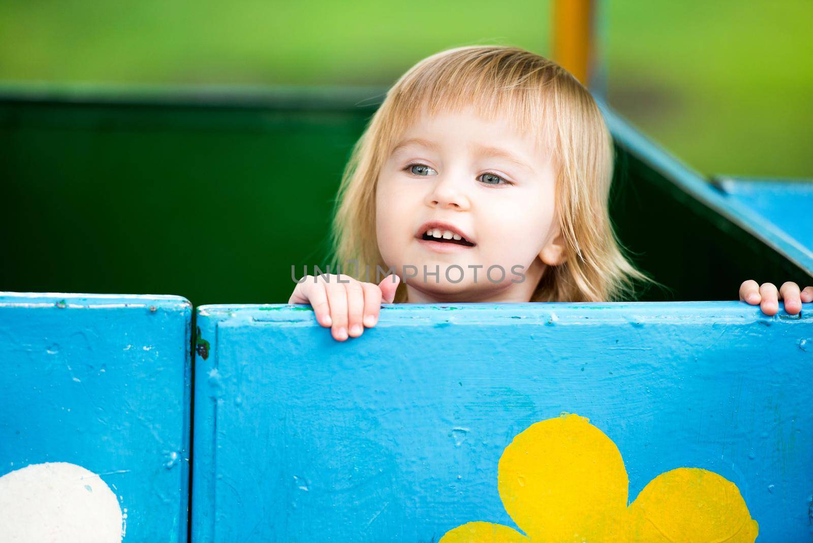 Portrait of two-year child at playground area in summer