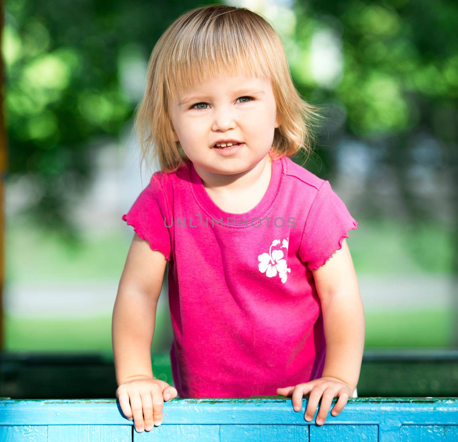 Portrait of two-year child at playground area in summer