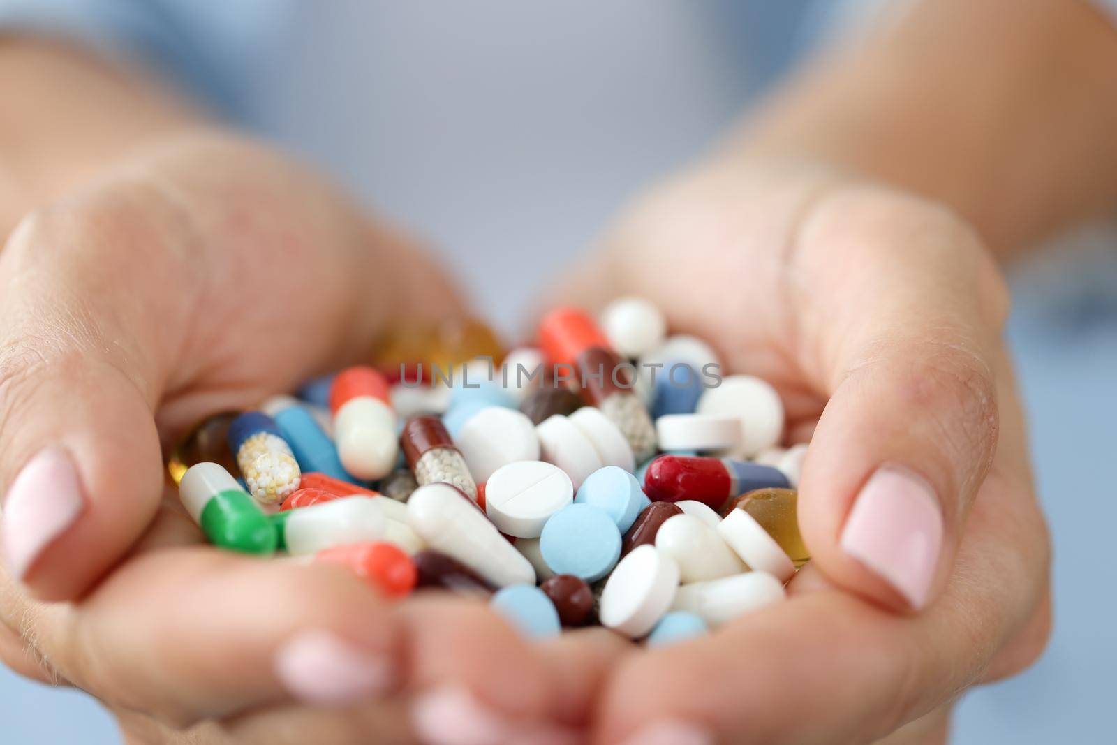 Colored pills and capsules in the palms, close-up. Food supplements, homeopathy. Treatment during a pandemic