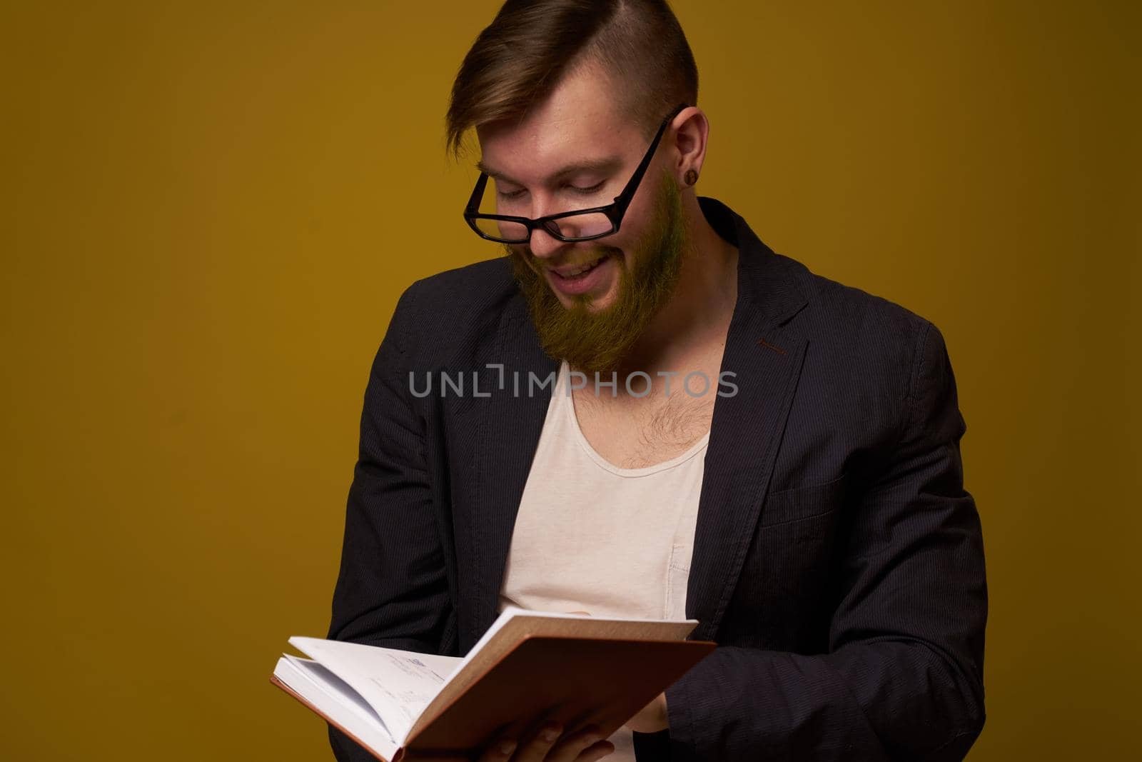 bearded man in a black jacket with a book in his hands education. High quality photo