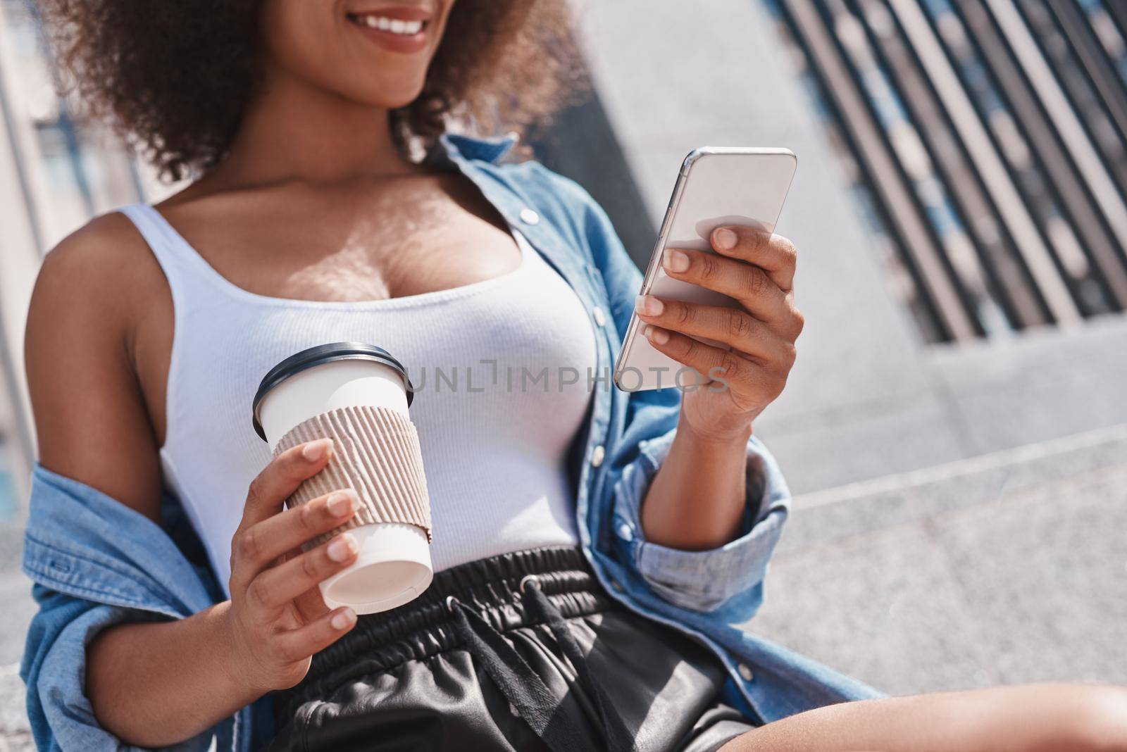 Young woman free style on the street sitting on stairs with cup by friendsstock