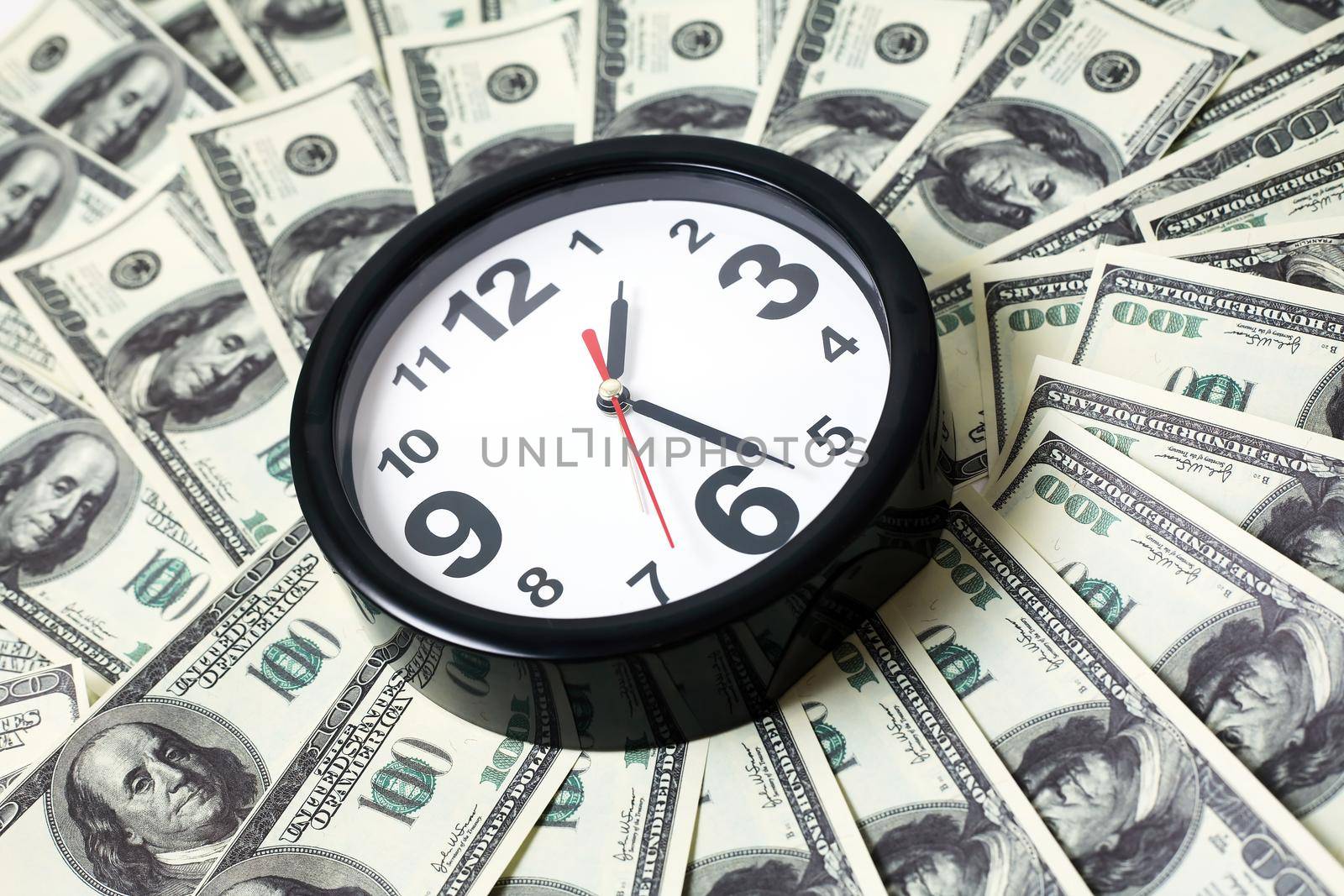 Time is money. Modern alarm clock on USA cash background