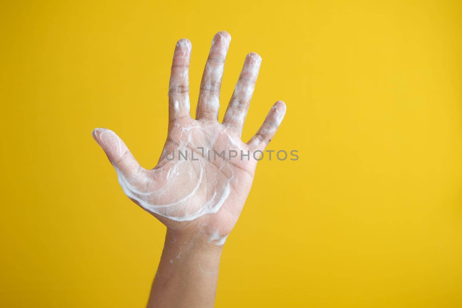 young man washing hands with soap warm water.