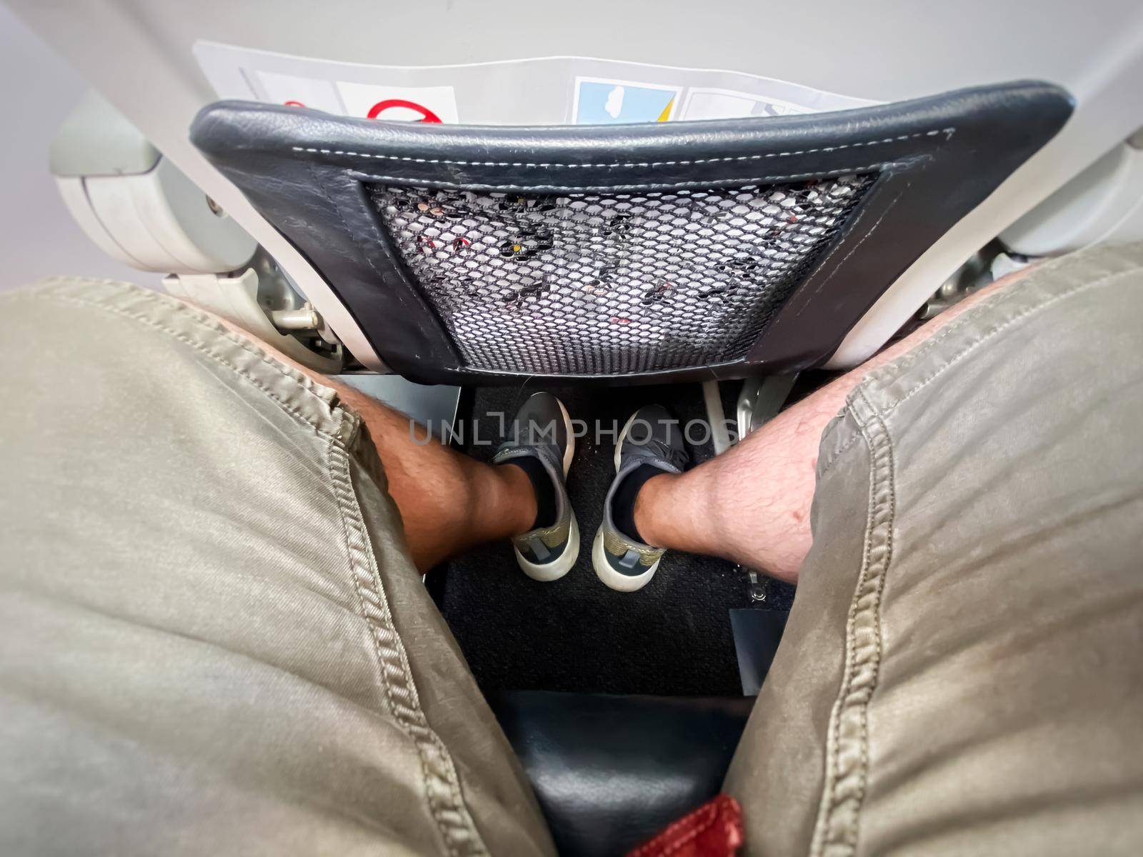 The legs of a man sitting in an airplane. by rarrarorro