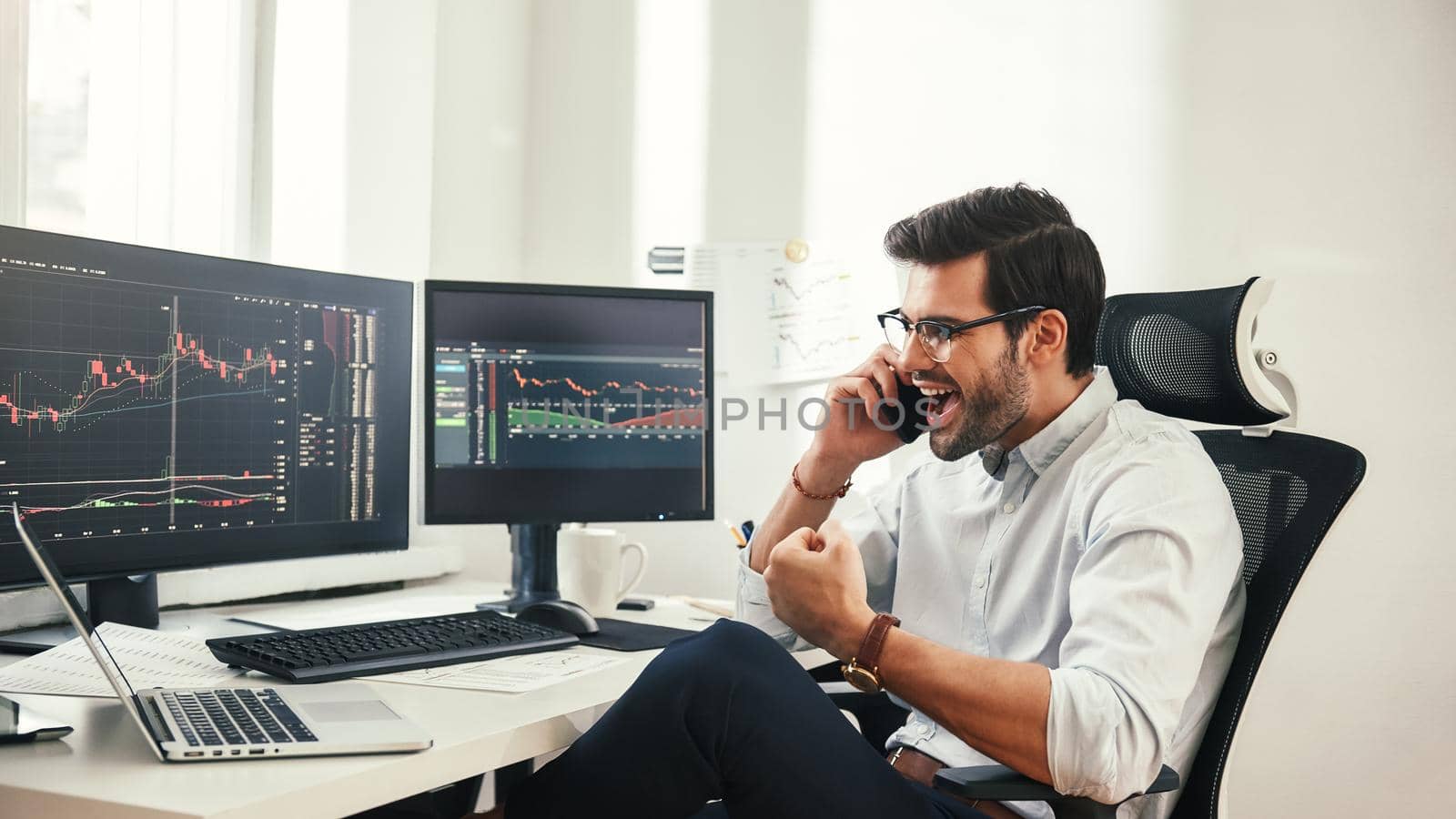 Success Happy bearded businessman or trader in formalwear and eyeglasses is talking with client and gesturing while working in modern office. Business concept. Trade concept. Investment concept