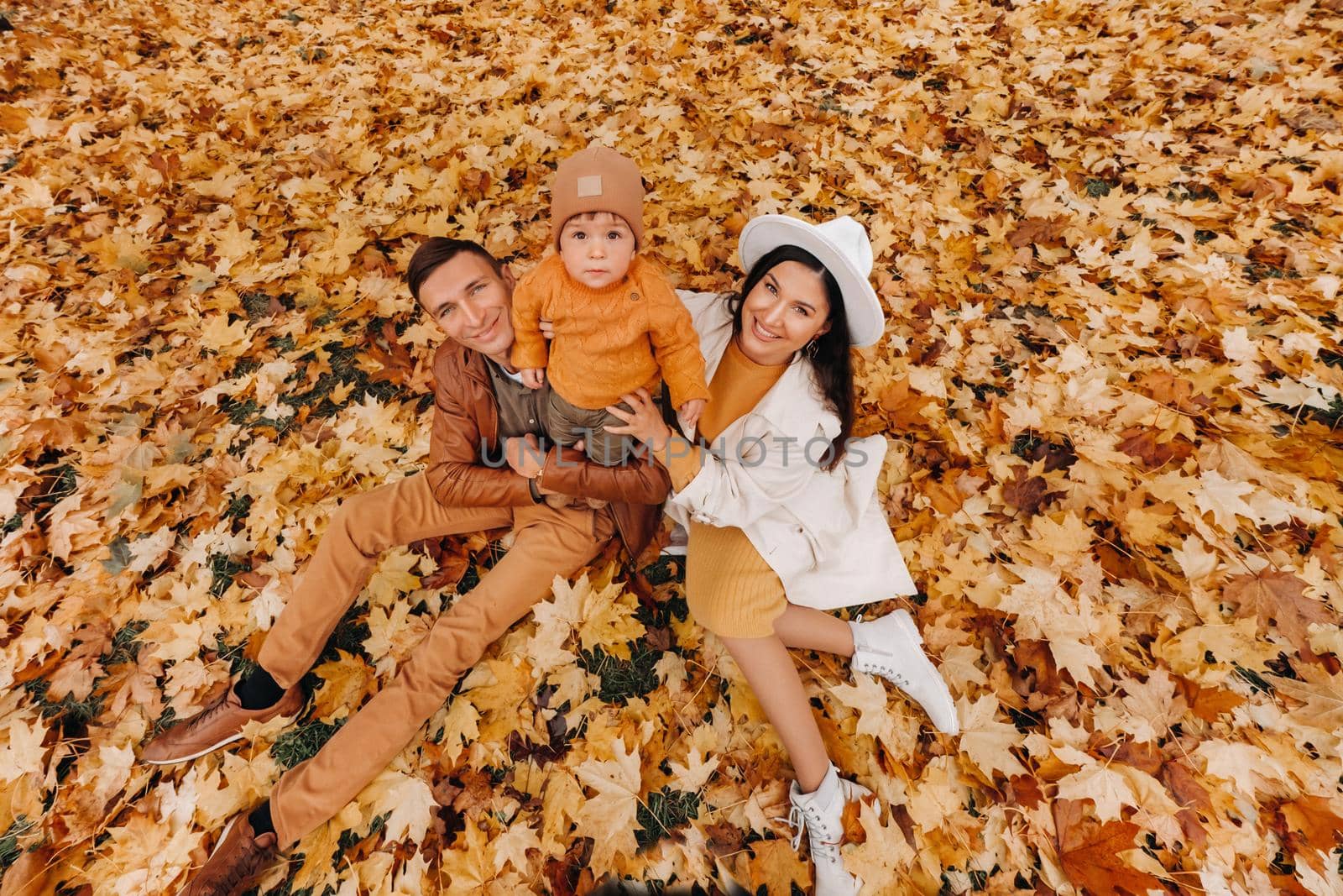 Father and mother with son walking in the autumn Park. A family walks in the Golden autumn in a nature Park