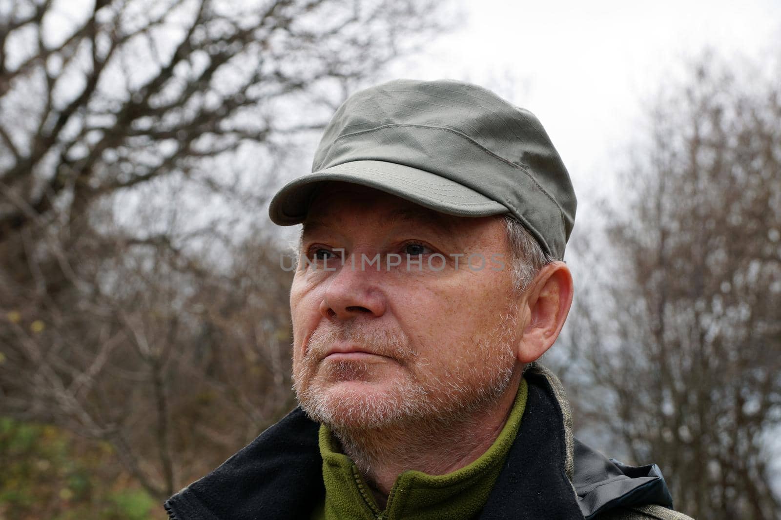 portrait of an older man in a cap on the background of nature by Annado