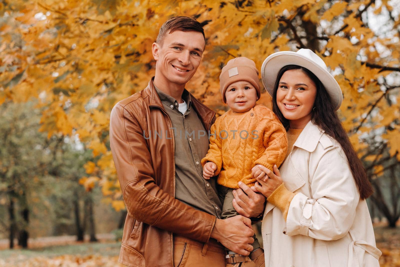 Father and mother with son walking in the autumn Park. A family walks in the Golden autumn in a nature Park