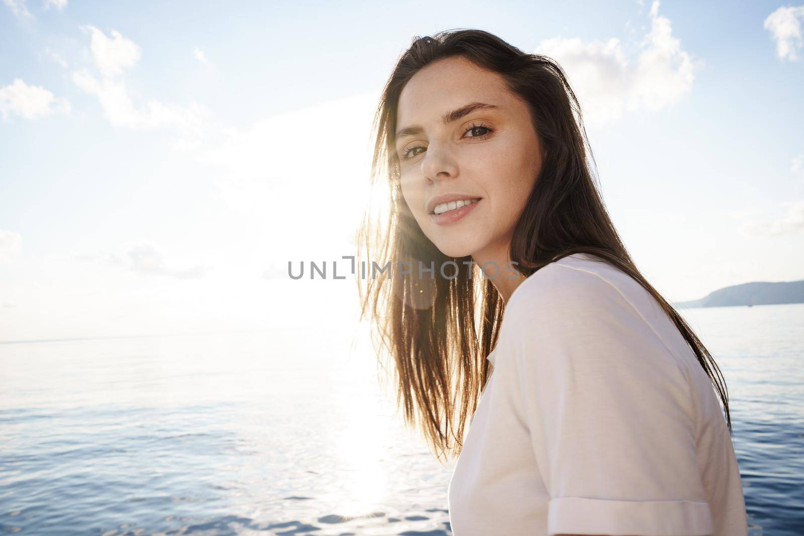 Portrait of young beautiful woman standing on boat against sea backgorund, close up