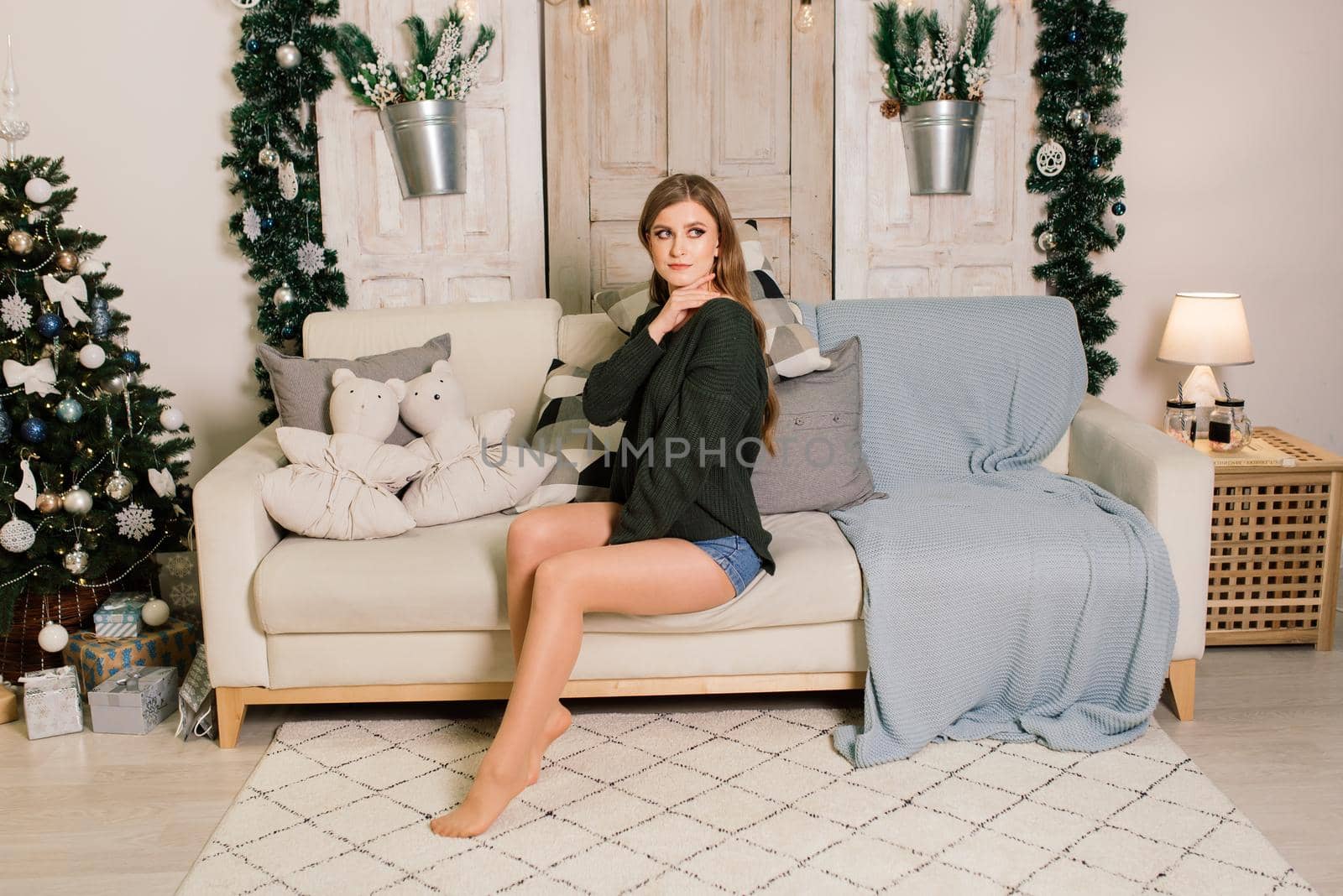 Beautiful young woman celebrating christmas at home, having fun opening presents