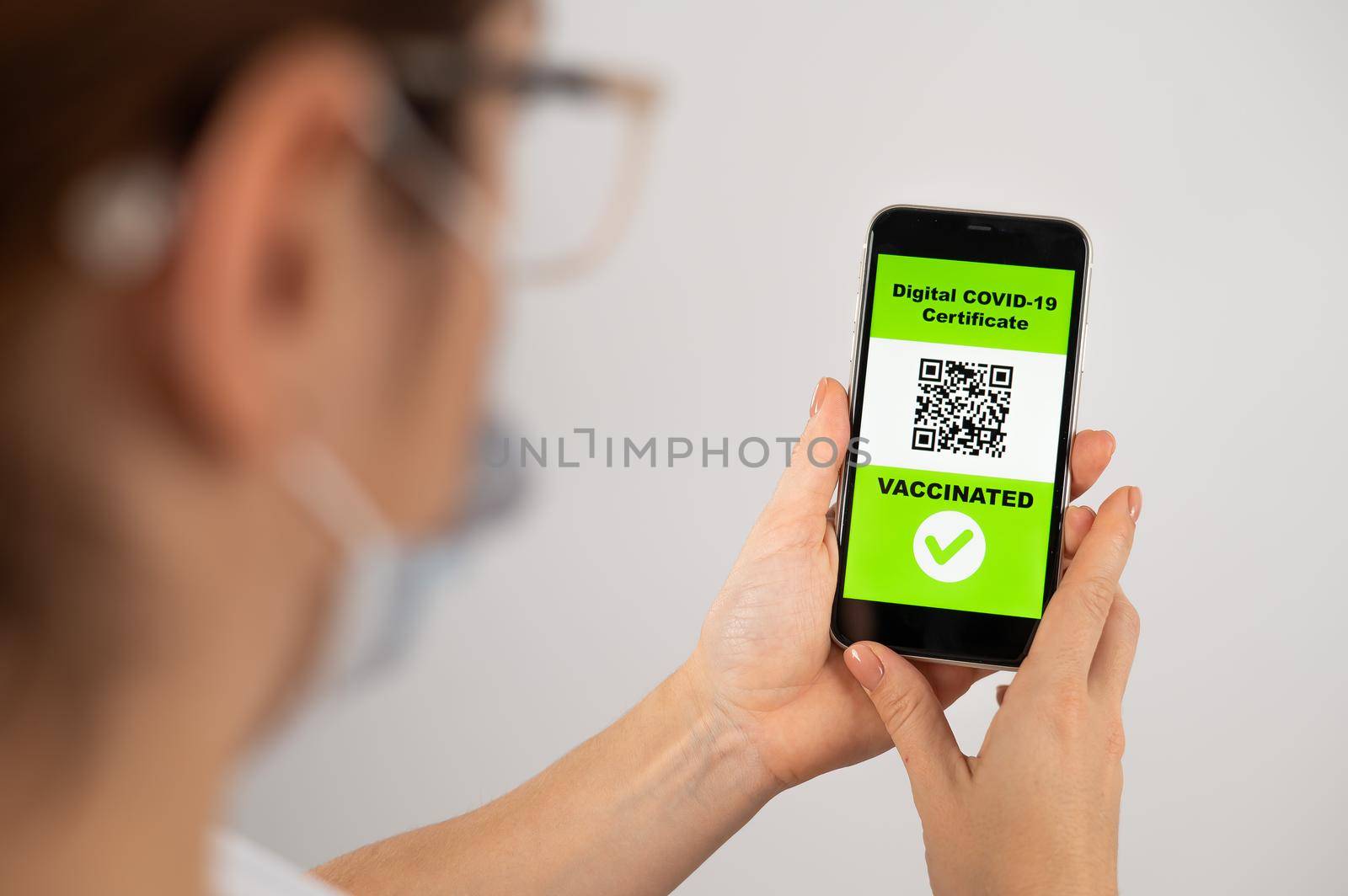The doctor holds a smartphone with a QR code about the vaccination performed. by mrwed54