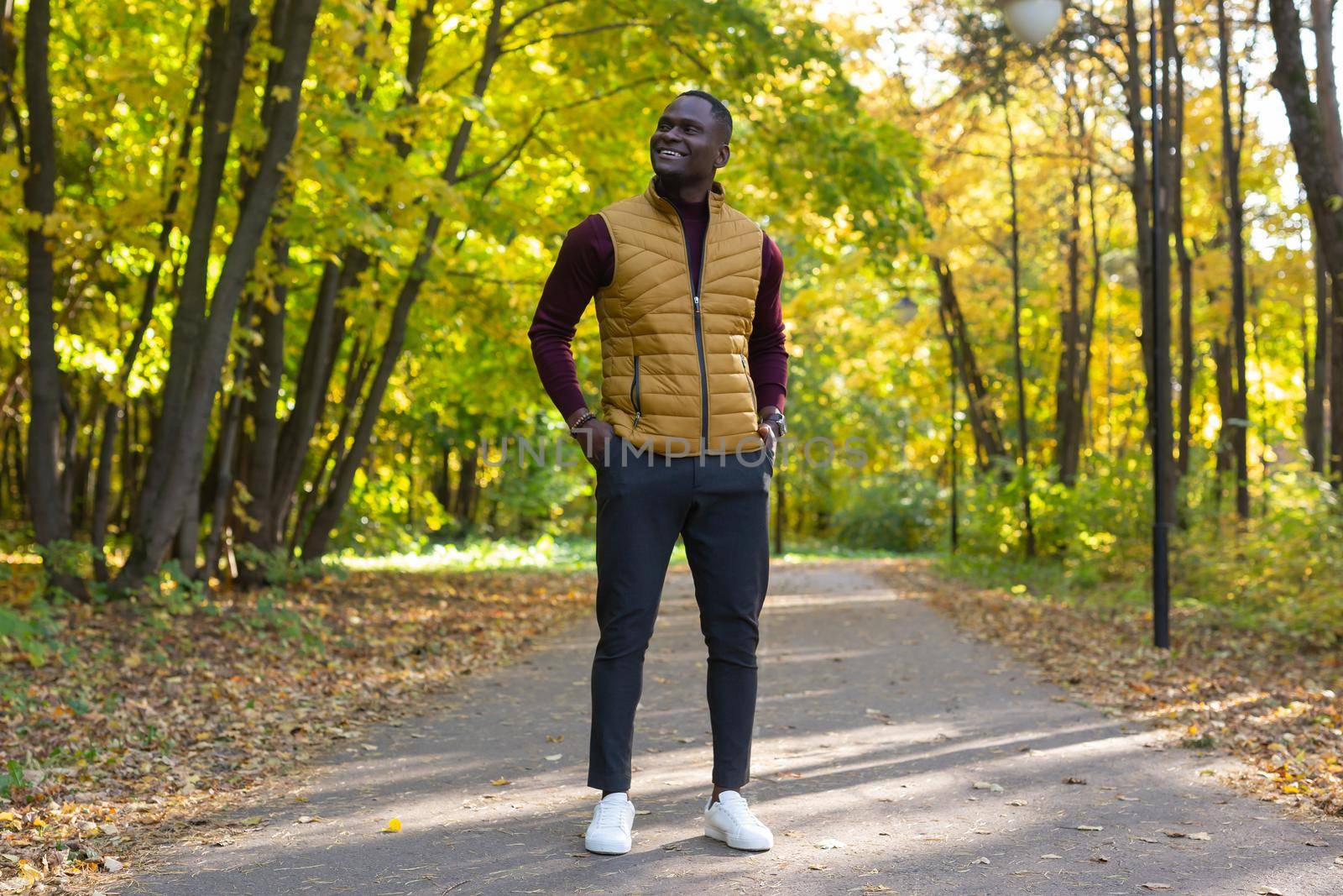 Hipster african american man walking in autumn park by Satura86