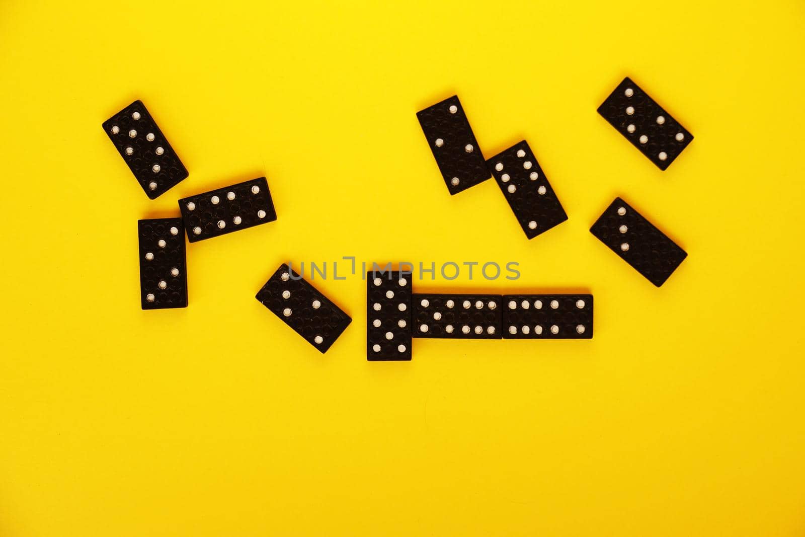 black domino bones on yellow background close-up