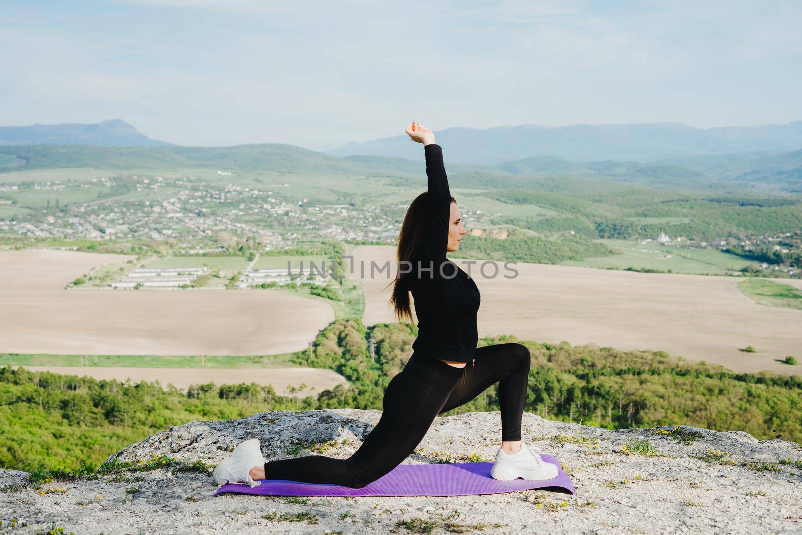 Yoga classes in the open air. Outdoor sports. A beautiful athlete in the mountains. Sports during quarantine and self-isolation.