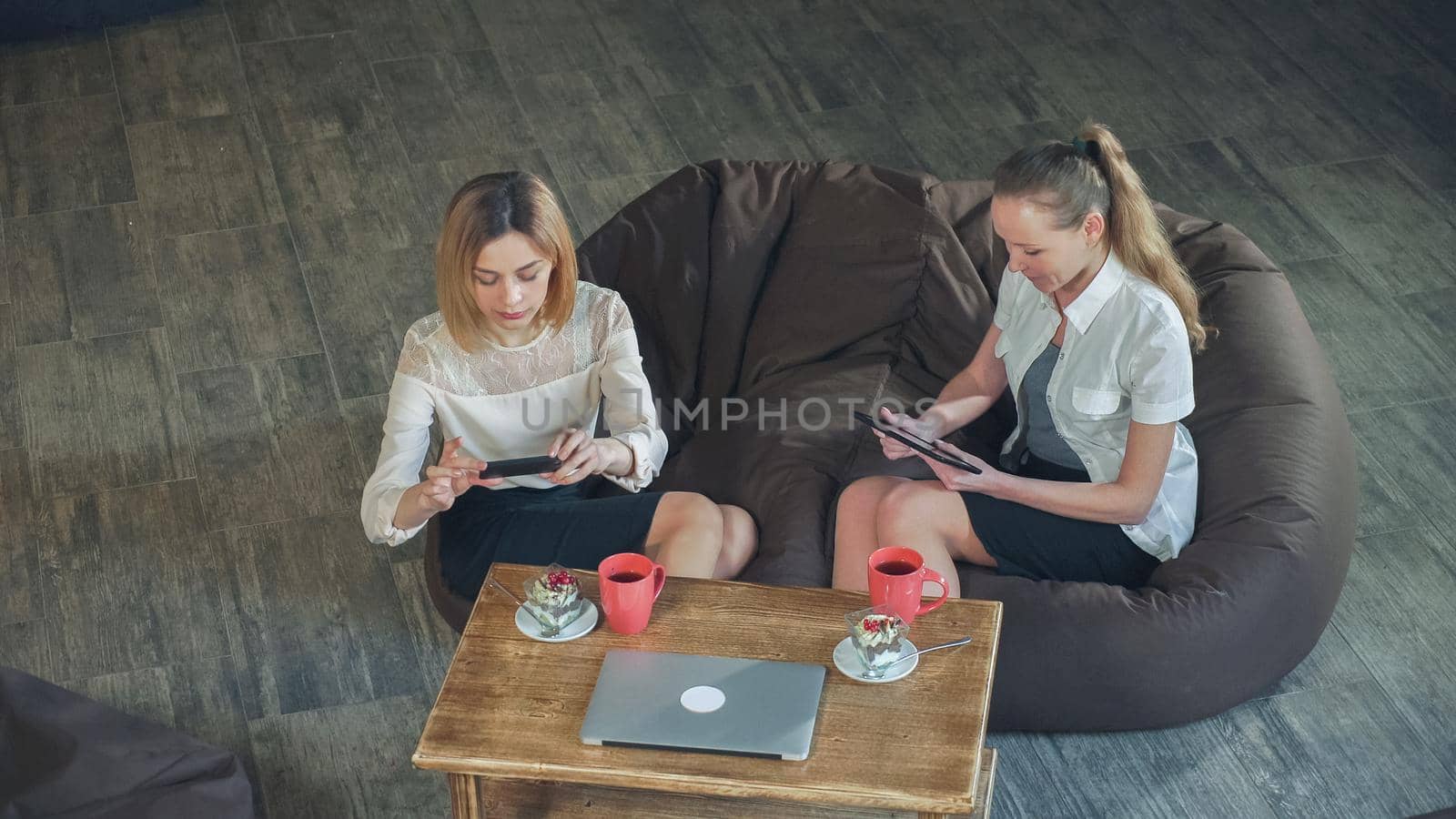 Woman in the cafe take a photo her dessert and showing her friend