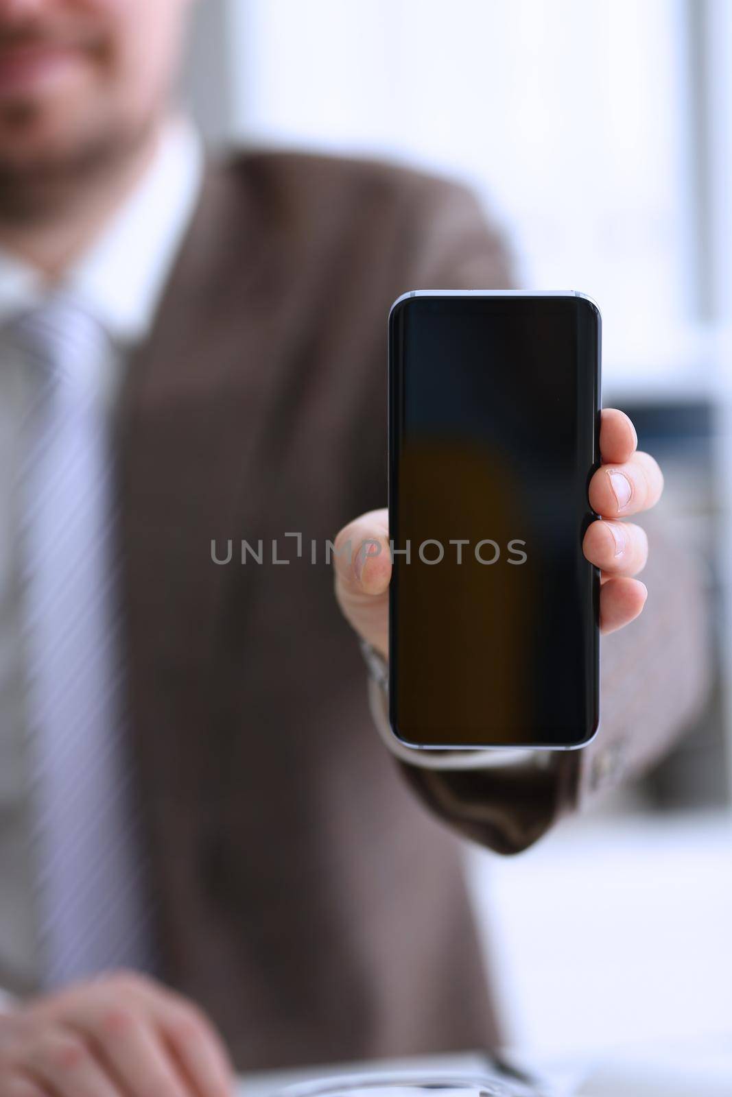 Male arm in suit show in camera phone display screen closeup. Read news mania send sms chat addict use electronic bank modern lifestyle job plan colleague share blog tweet web application search