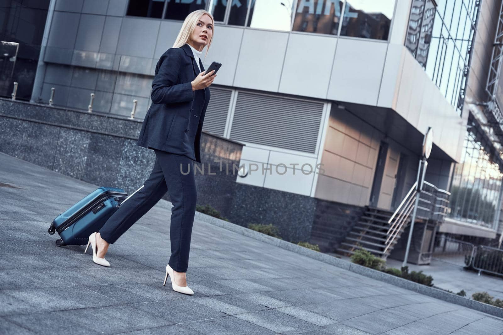 Travel, business trip. People and technology concept - happy young woman with travel bag on city street