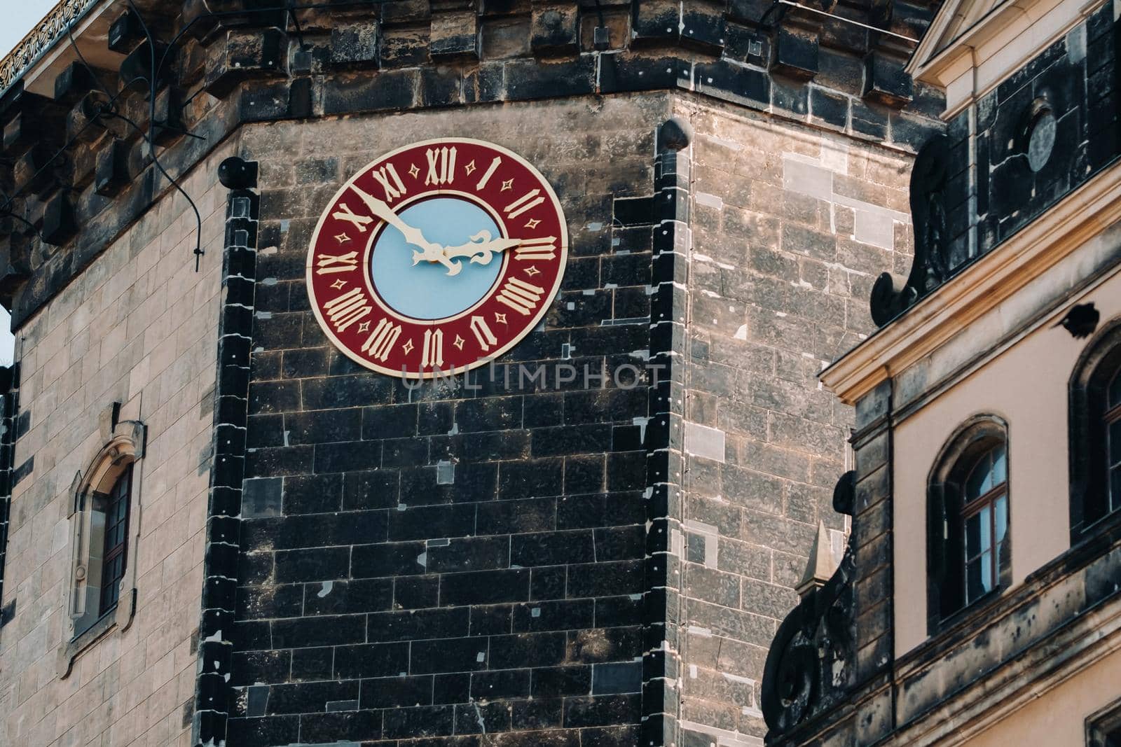 Dresden, the red great clock of the Dresden castle tower, the residence of the old kings in the city center, the Baroque Museum complex, illuminated by the sun.