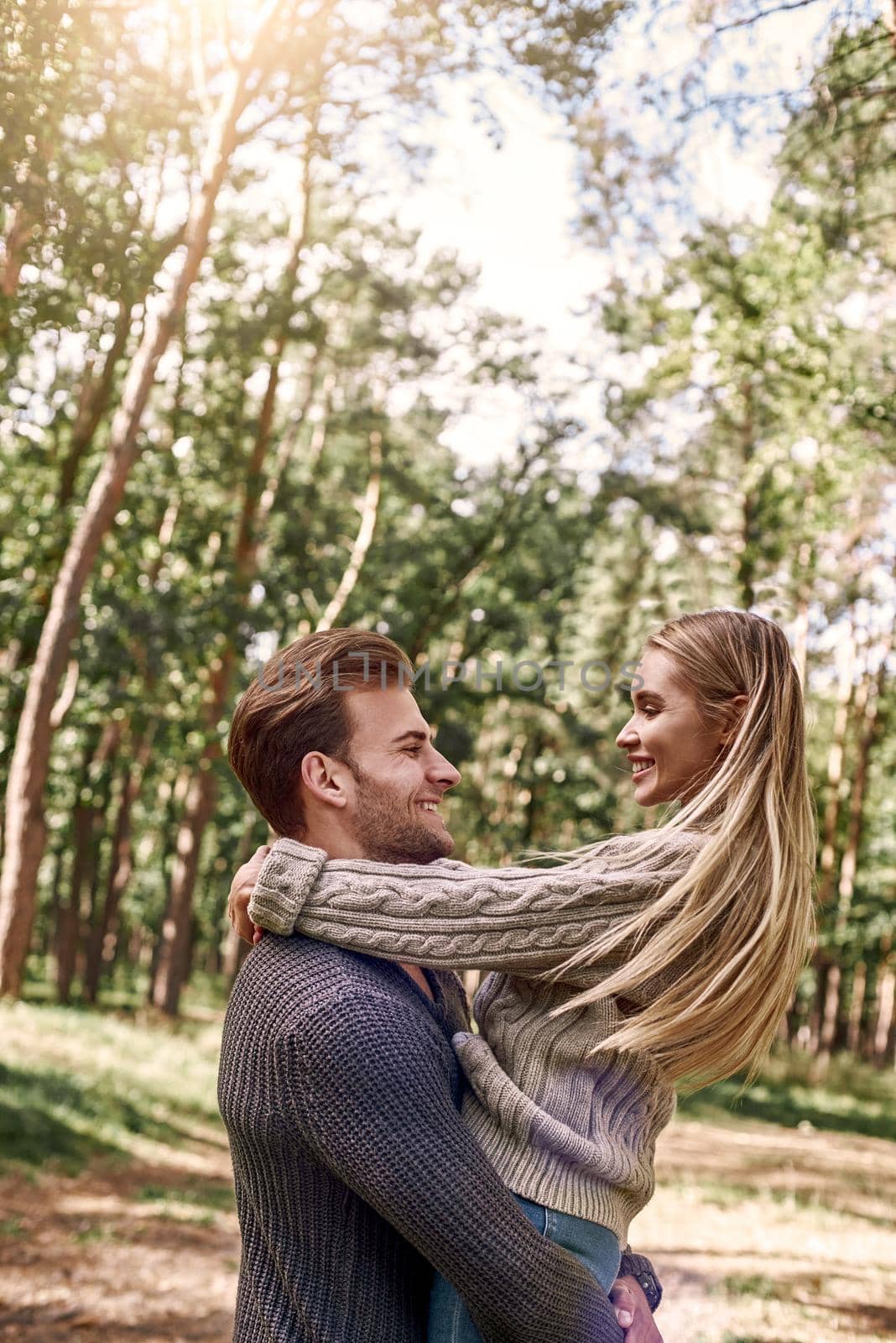 Outdoor happy couple in love posing in autumn forest. Young woman and man having fun outdoor