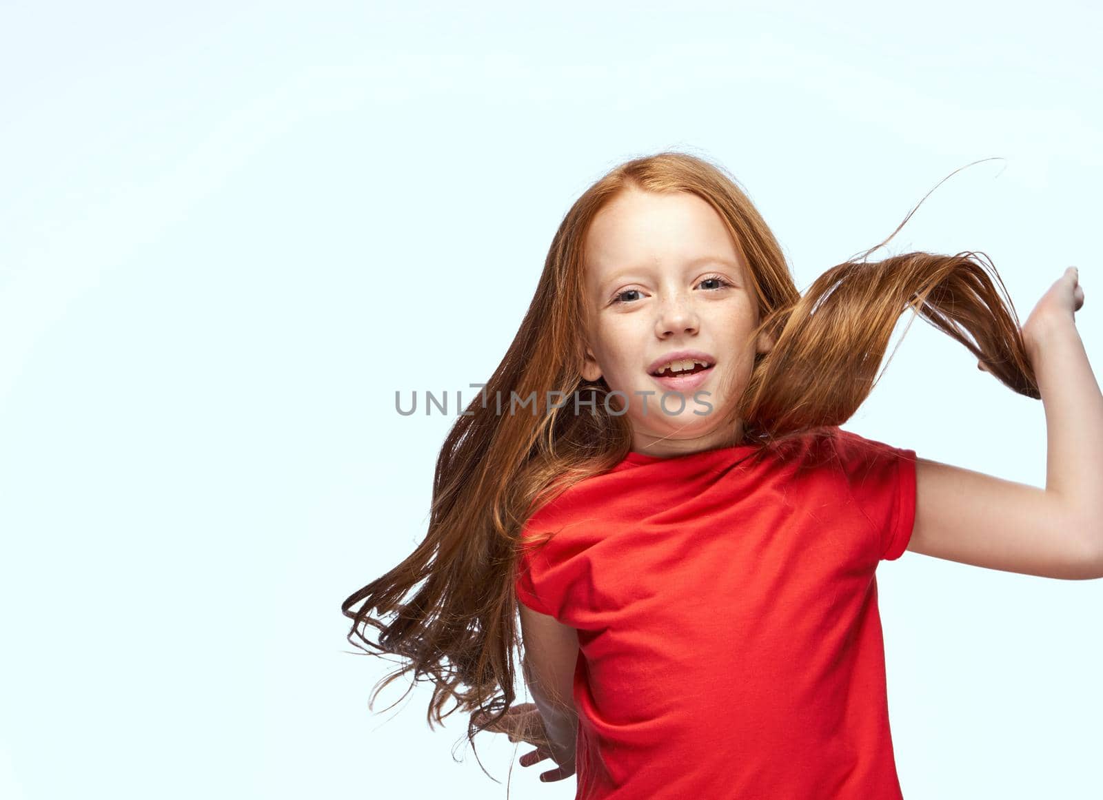 girl with red hair posing red t-shirt childhood. High quality photo