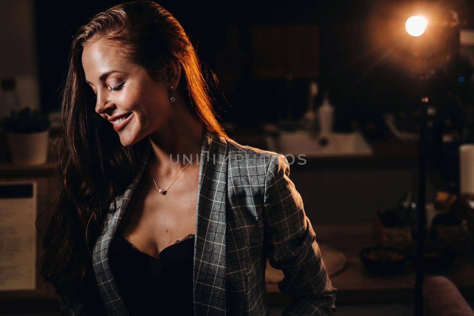 Portrait of a young European girl with long hair in a coffee shop in the evening light, a tall Girl in a jacket with long hair in a cafe.