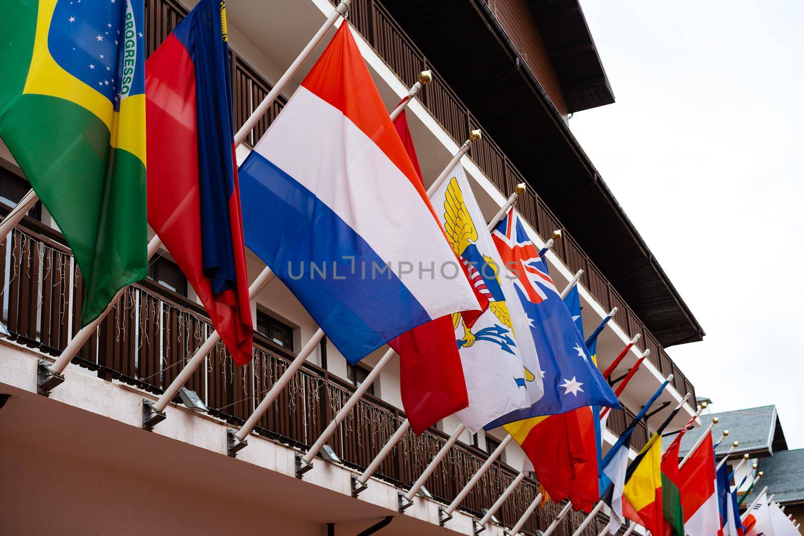 Many flags of different states fluttering on the facade of building, close up