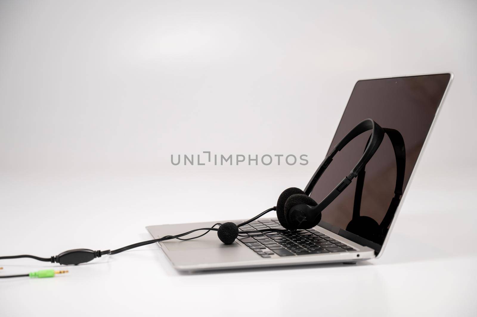 Headset on laptop keyboard on white background