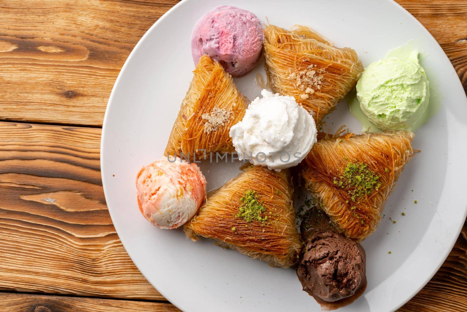 Close up photo of Turkish baklava served with ice cream on plate