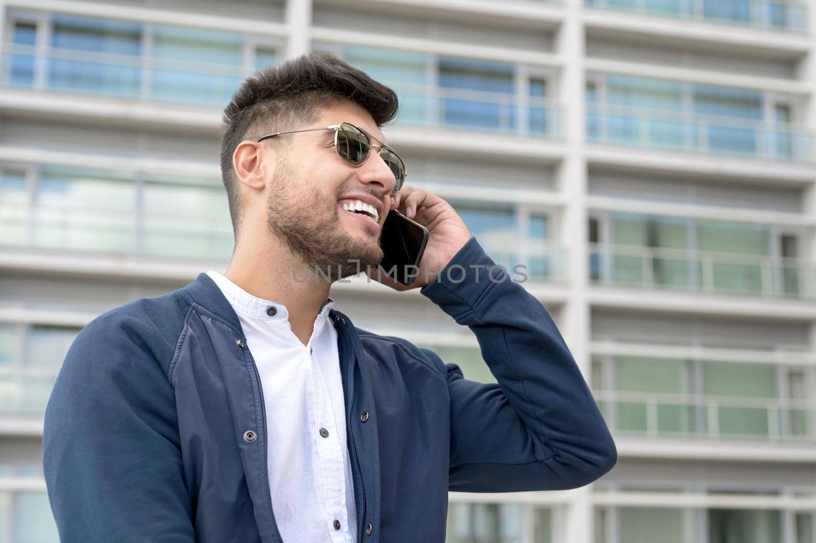 Handsome Man talking on cellphone outside modern office building. High quality photo