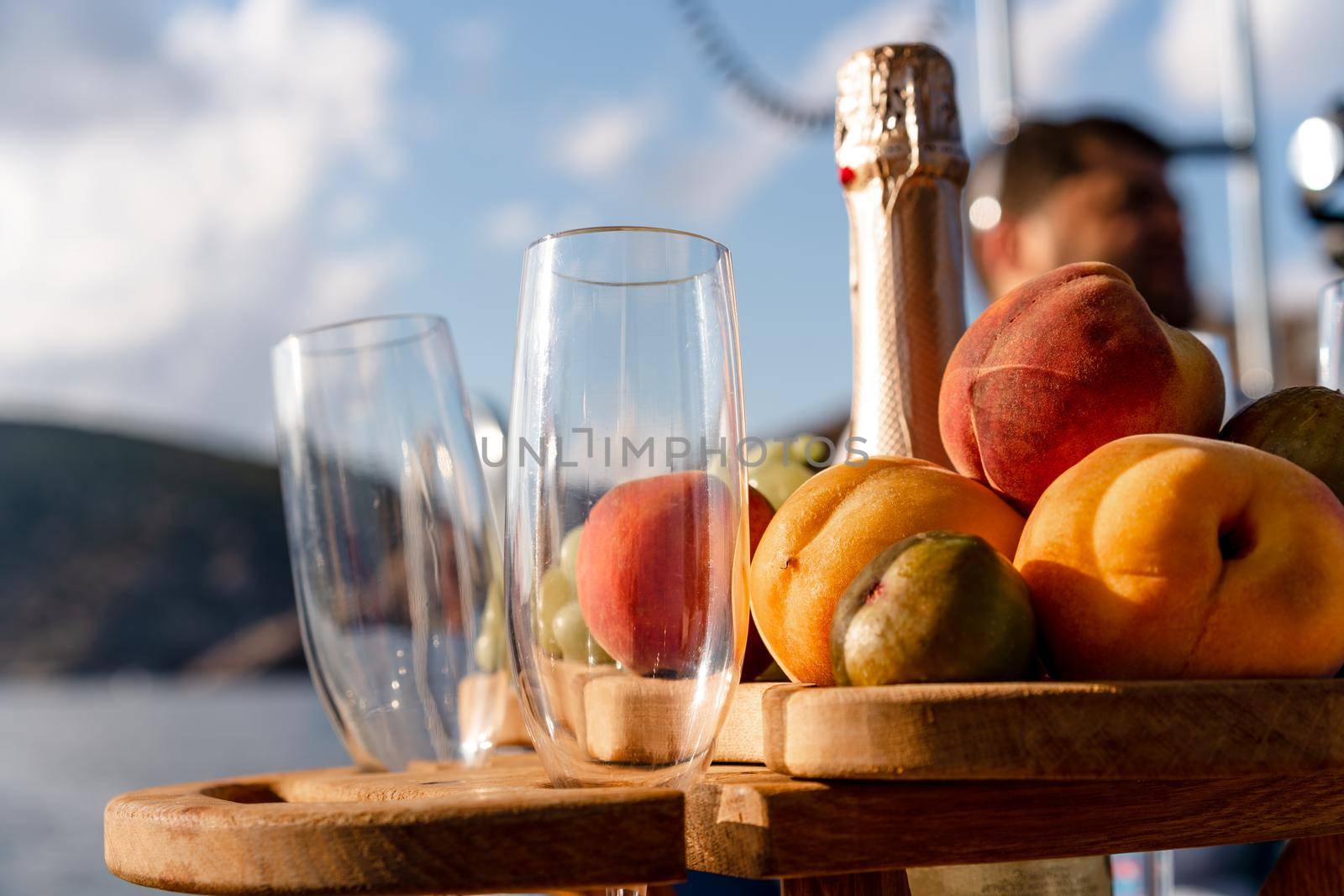 Fruit tray and bottle of champagne for romantic date on a yacht, close up