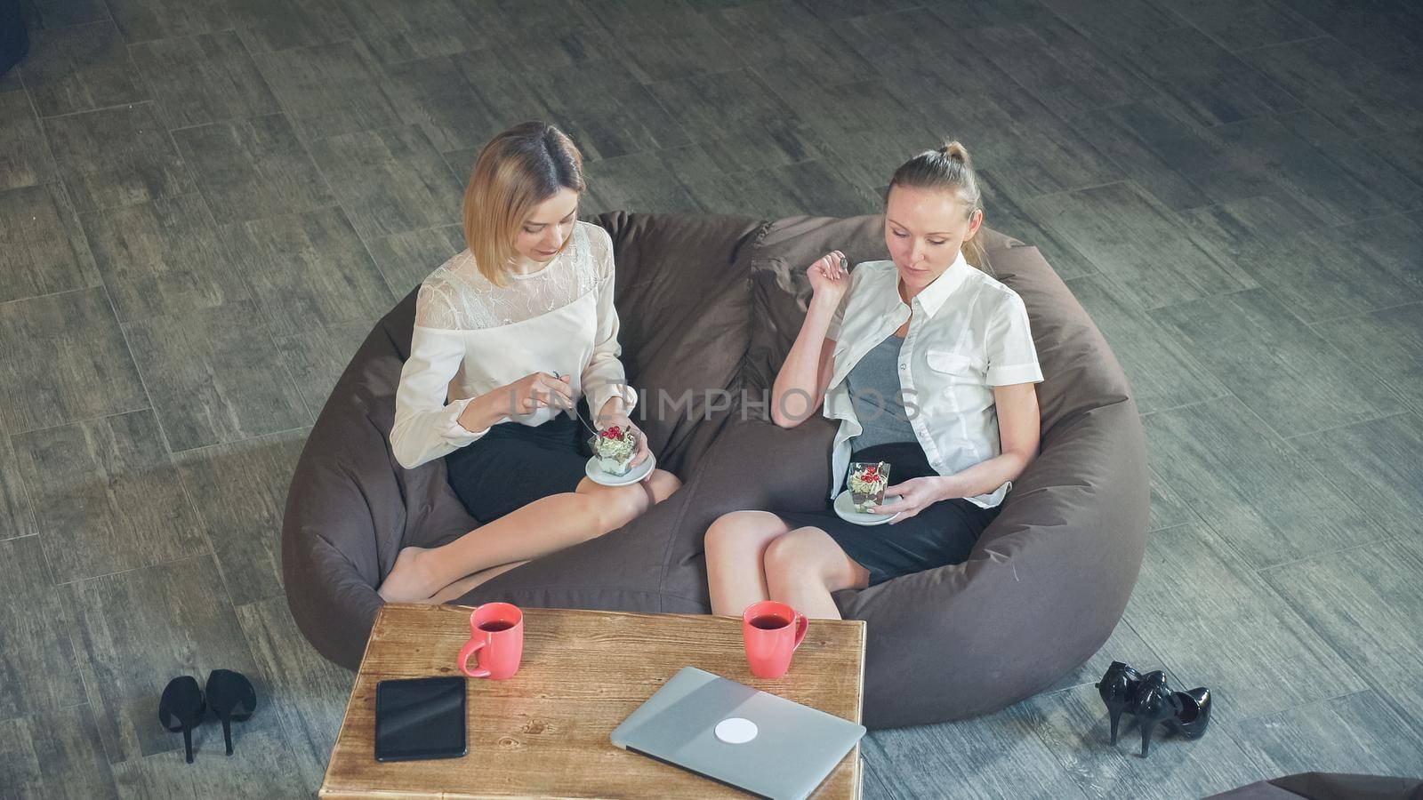 Two women friend eating delicious dessert with fruts in the cafe Top view of a static video.