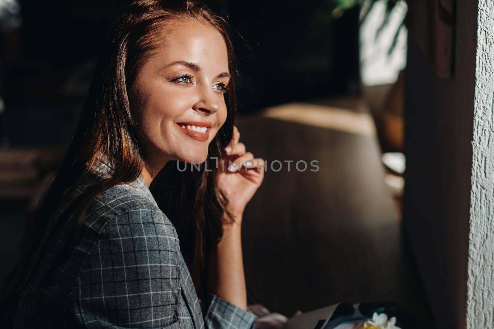 Portrait of a young European girl with long hair in a cafe with a bouquet standing near the window, a tall girl in a jacket with long hair in a cafe waiting by Lobachad