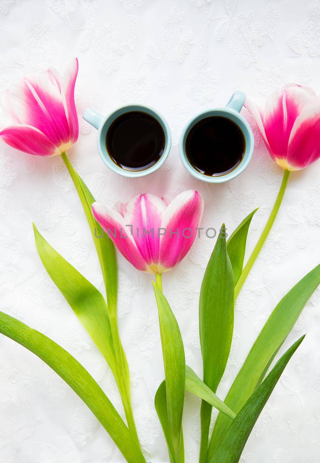 two cups of coffee and a bouquet of pink tulips. valentine card