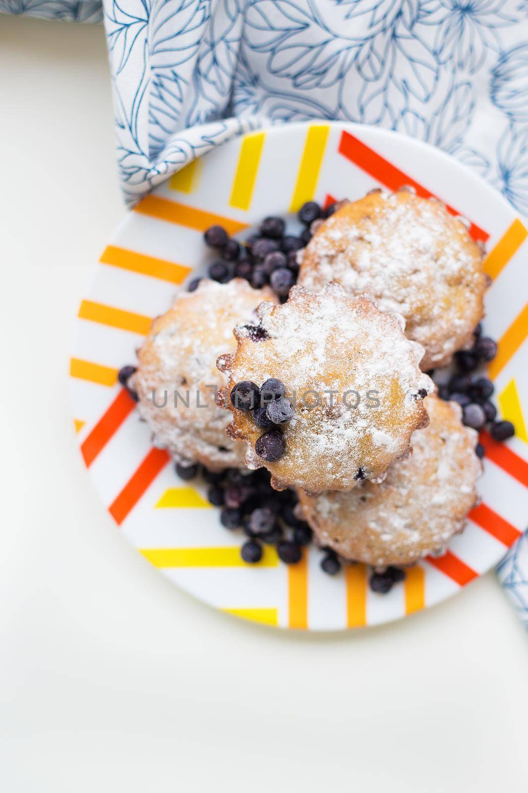 Blueberry muffins on plate and bright floral cloth