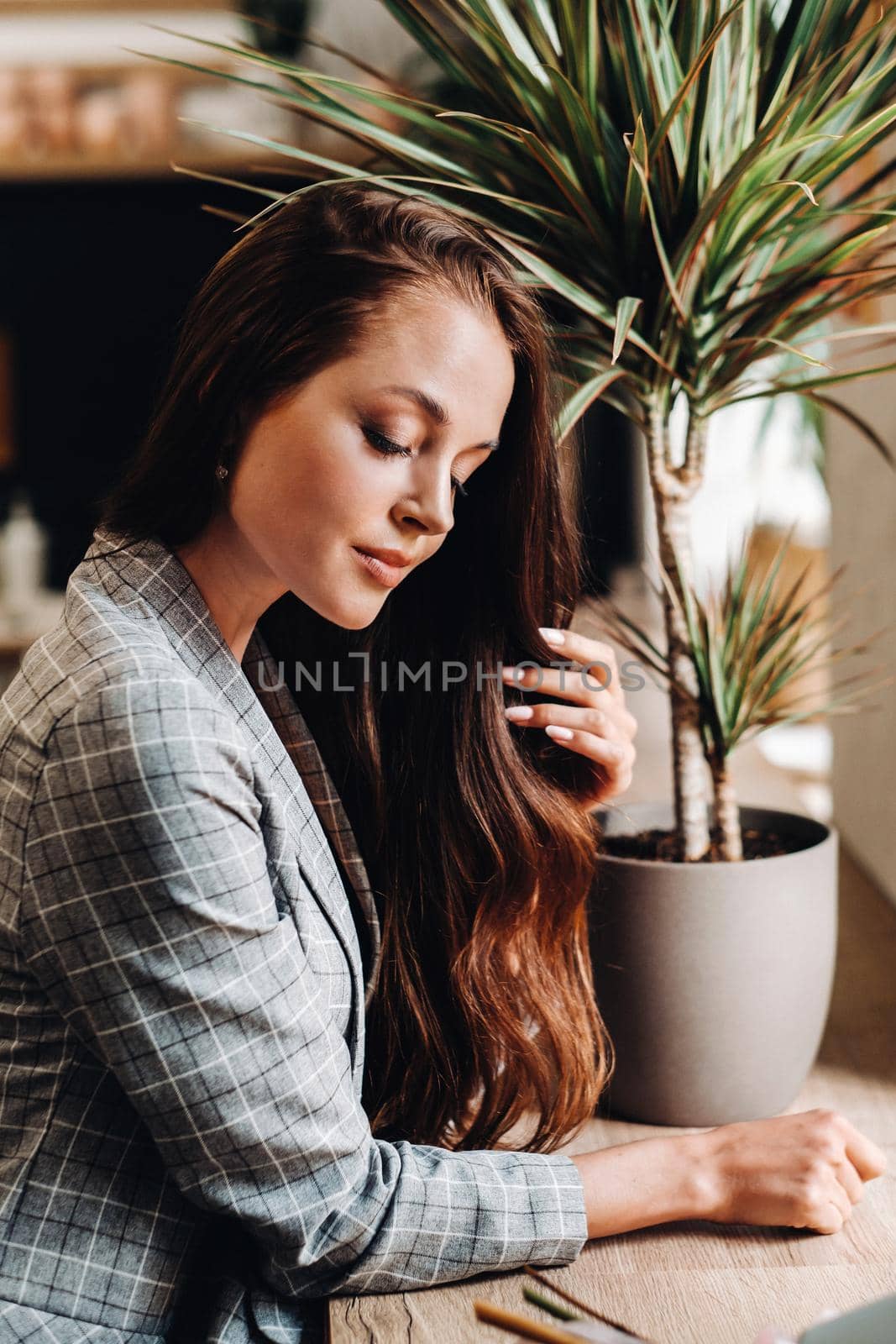 Portrait of a young European girl with long hair in a coffee shop in the evening light, a tall Girl in a jacket with long hair in a cafe by Lobachad