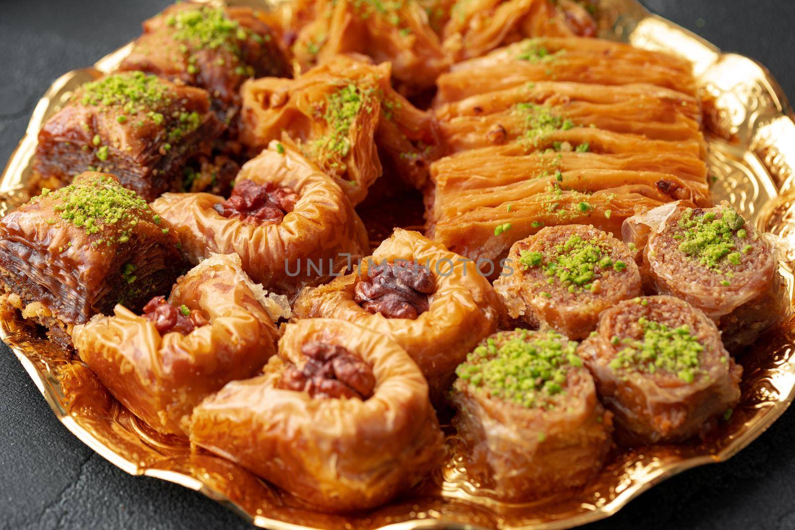 Delicious baklava dessert in oriental setting on black background, close up