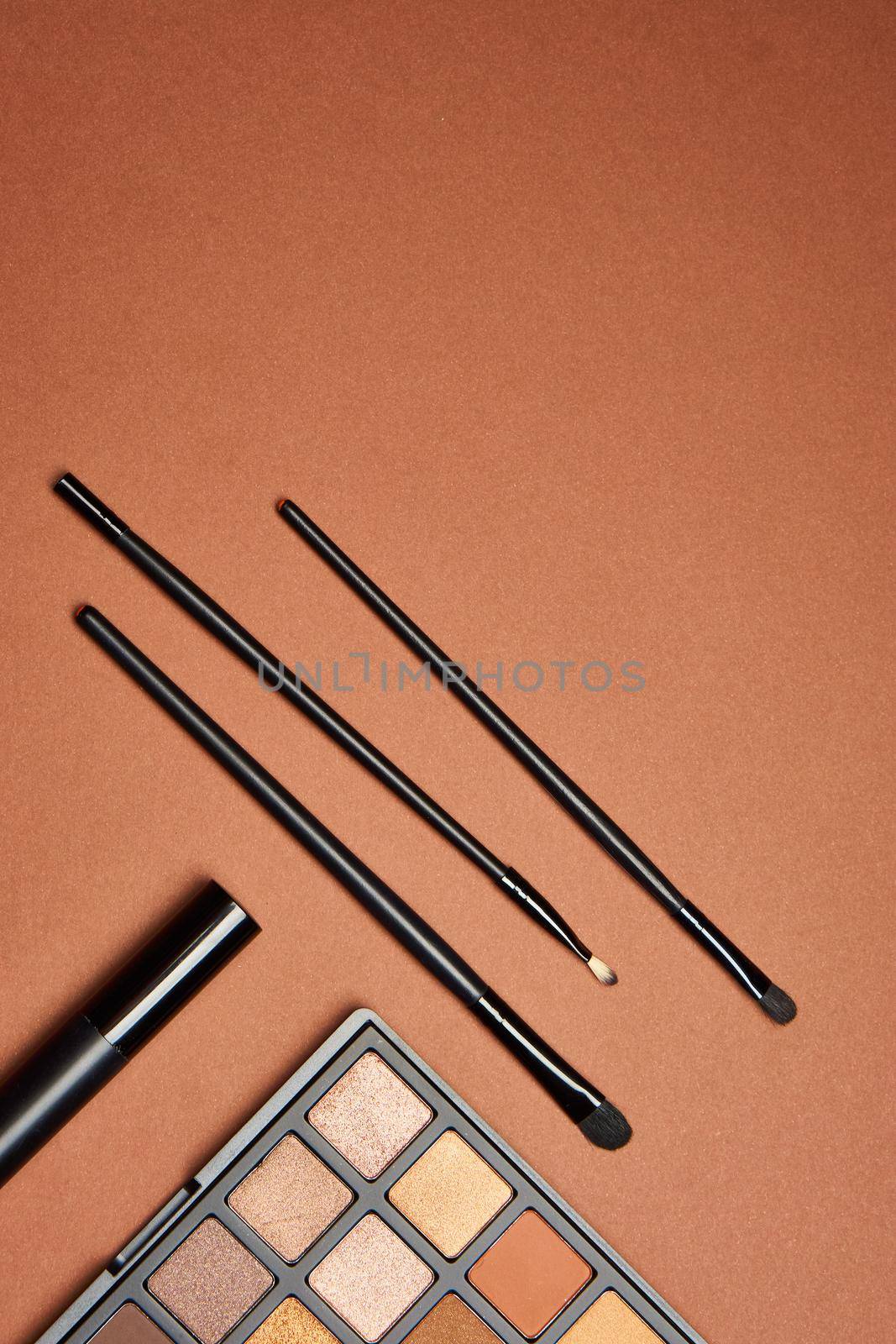 makeup brushes mascara accessories glamor brown background. High quality photo