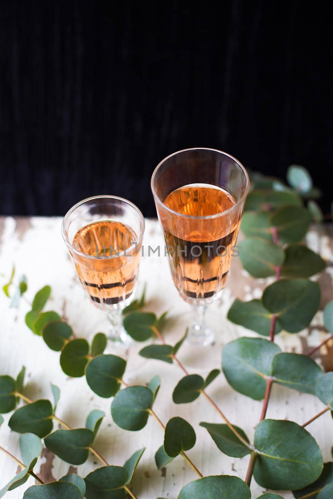 eucalyptus branches on an old table with a glass of rose wine