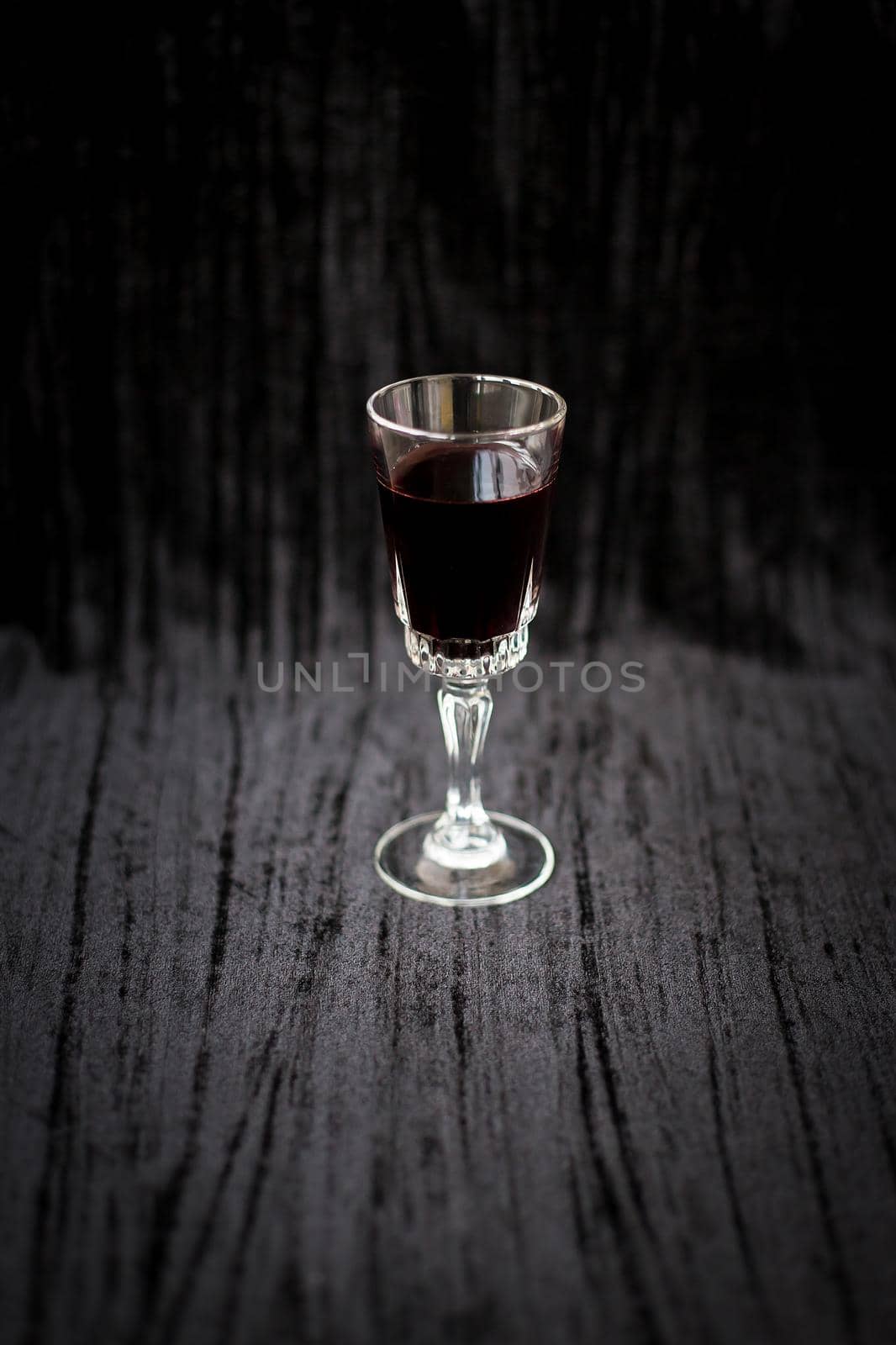glass of red wine on a black velvet background, close-up.