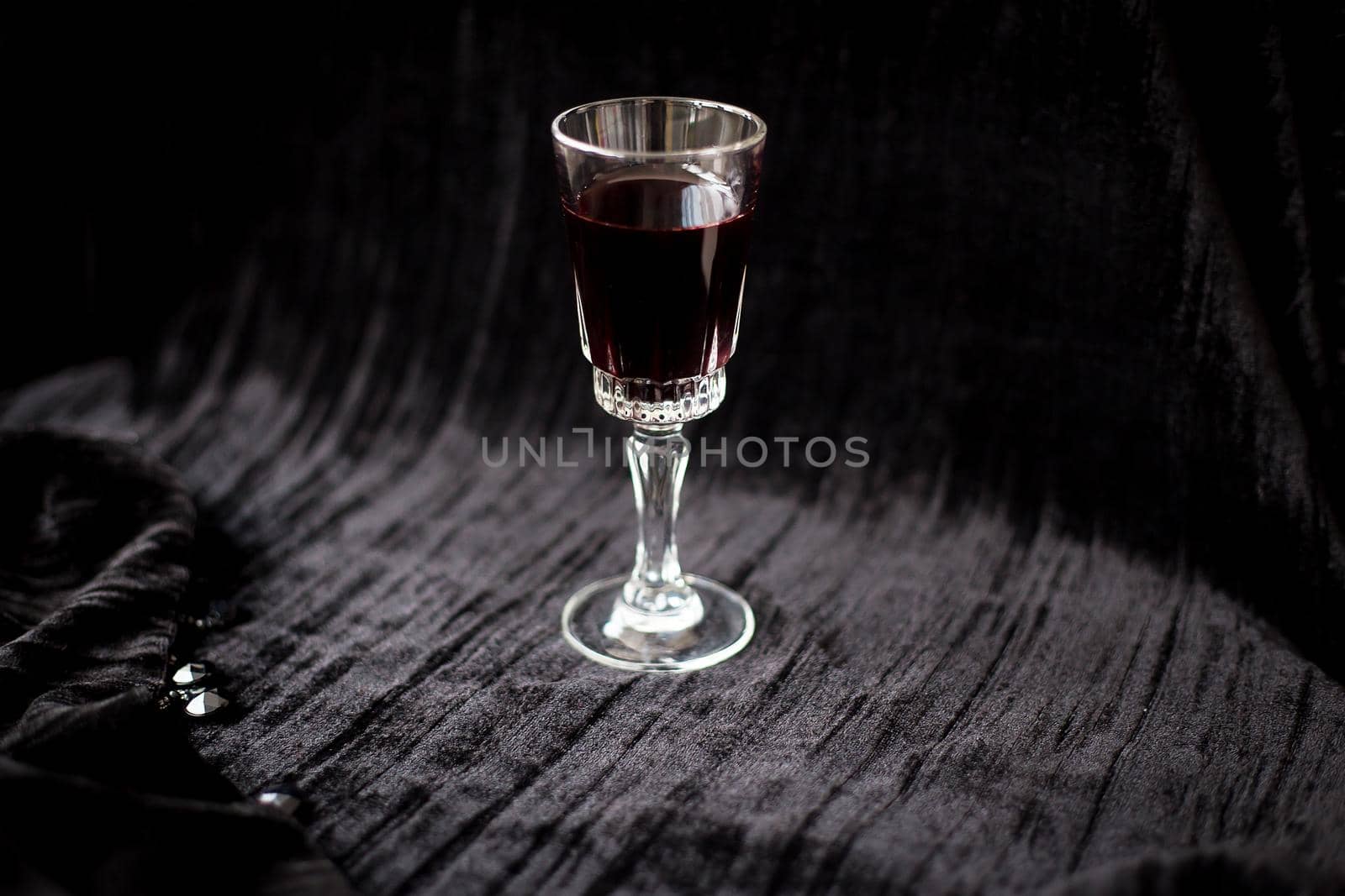 glass of red wine on a black velvet background, close-up by sfinks