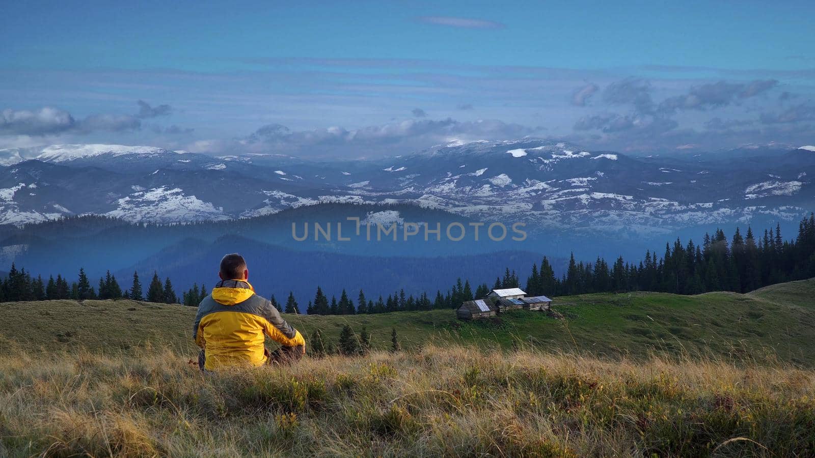 Traveler in the mountains. The peaks are covered with snow. Beautiful landscape of the Carpathian Mountains. Ukraine