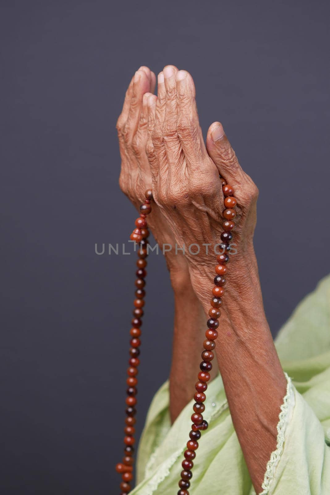 Close up of senior women hand praying at ramadan .