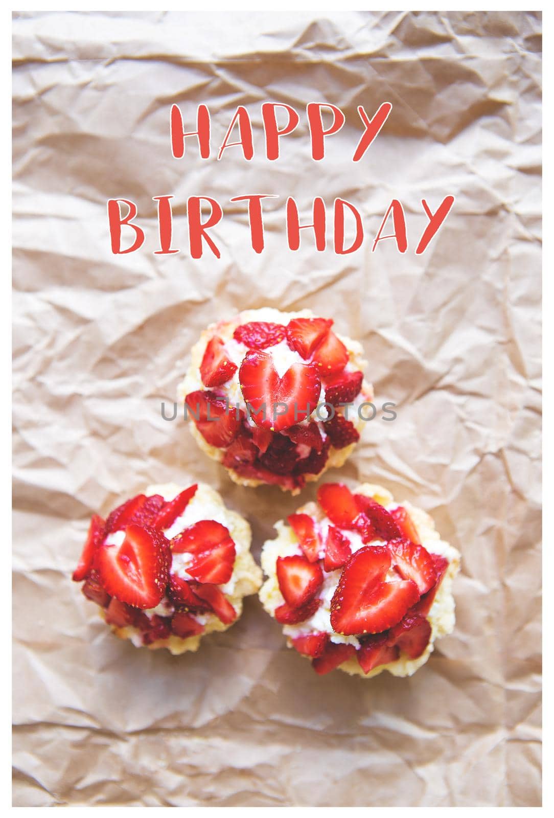 Beautiful and bright cupcakes with strawberries, the inscription of a happy birthday by sfinks