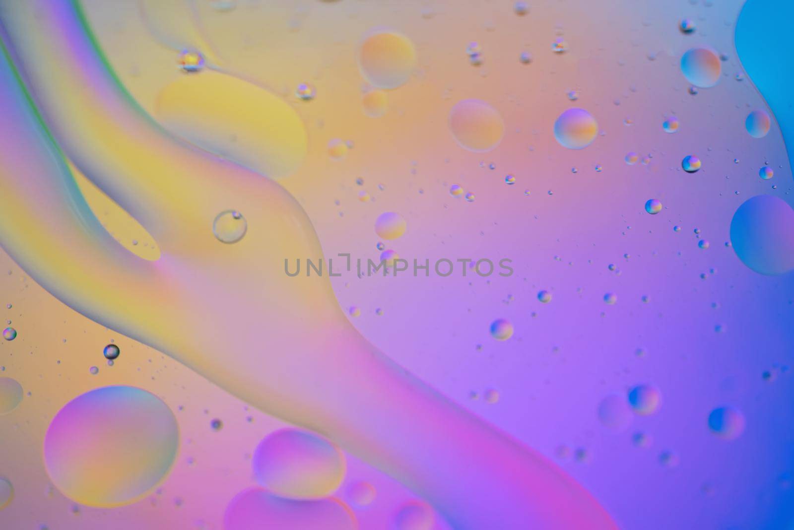 Oil drops in water. Abstract defocused psychedelic pattern image rainbow colored. Abstract background with colorful gradient colors. DOF.