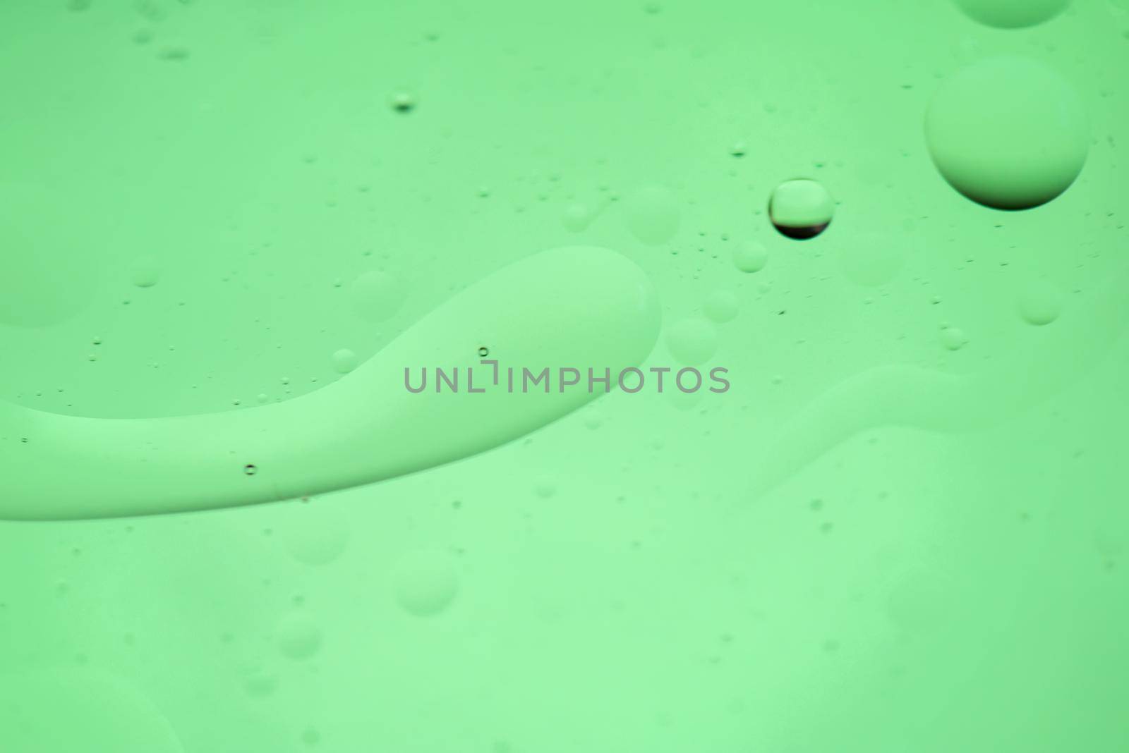 Green mint abstract background picture made with oil, water and soap by anytka