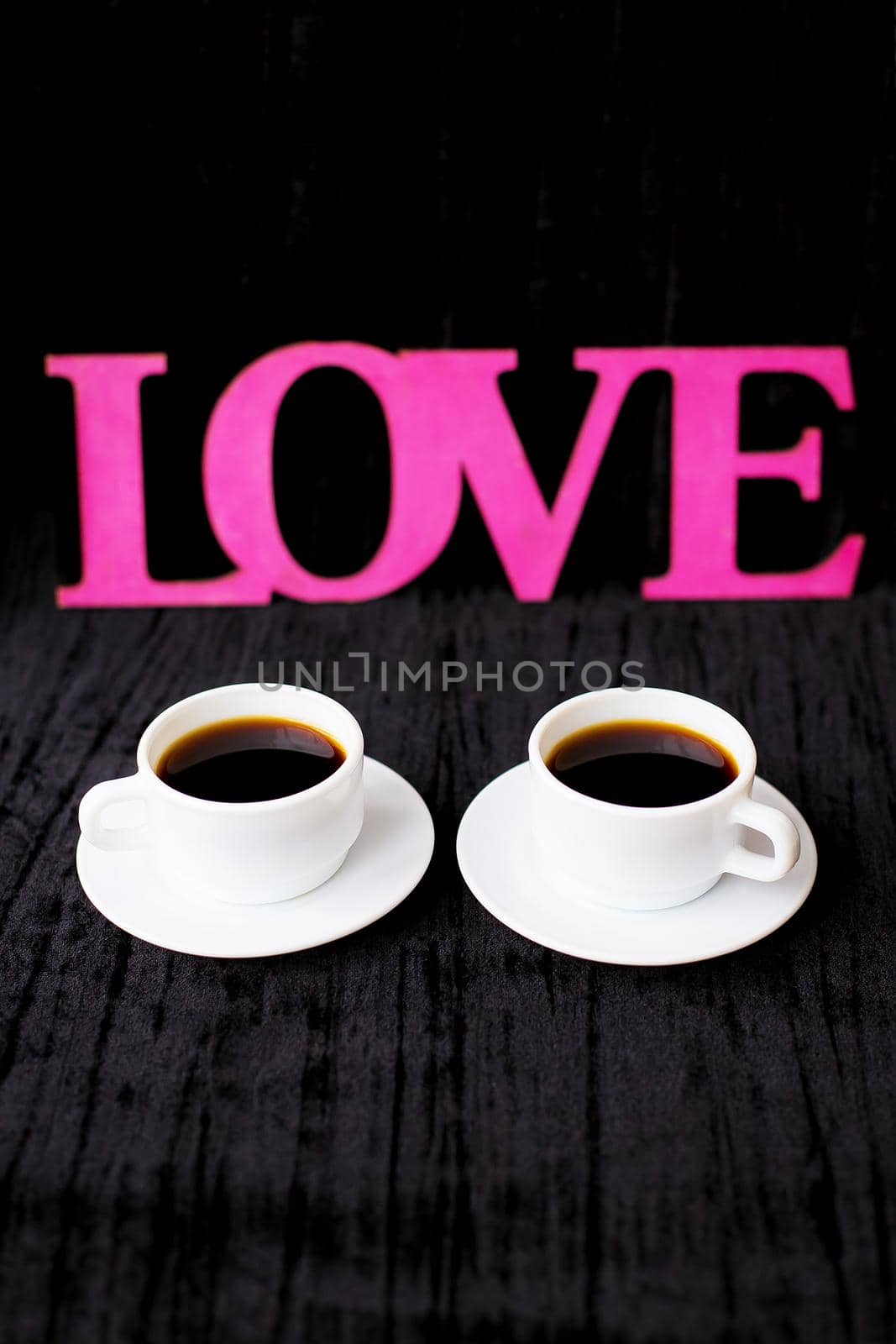 two cups of coffee on pink background inscription love Valentine's Day.