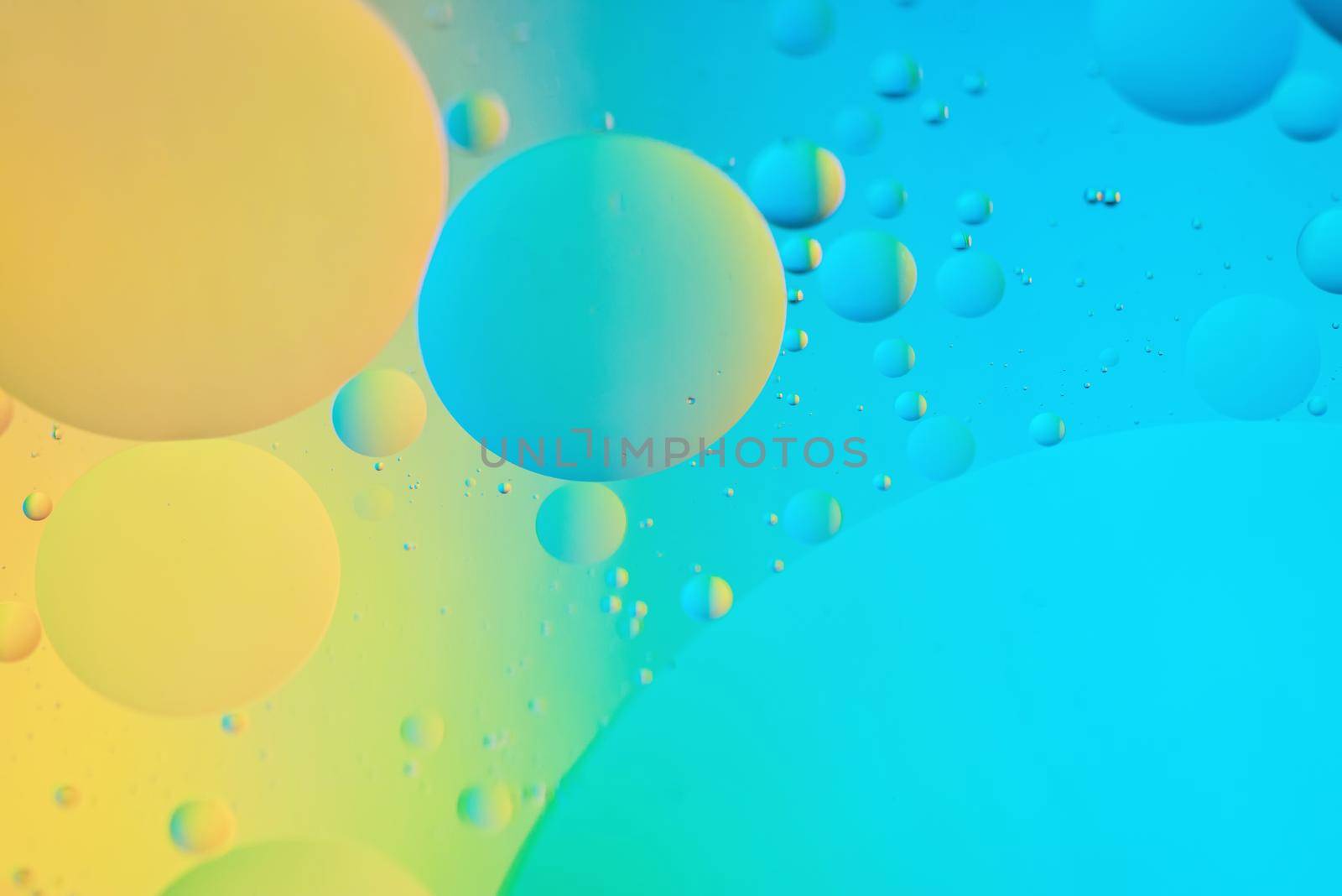 Oil drops in water. Abstract defocused psychedelic pattern image blue and yellow colored. Abstract background with colorful gradient colors. DOF.