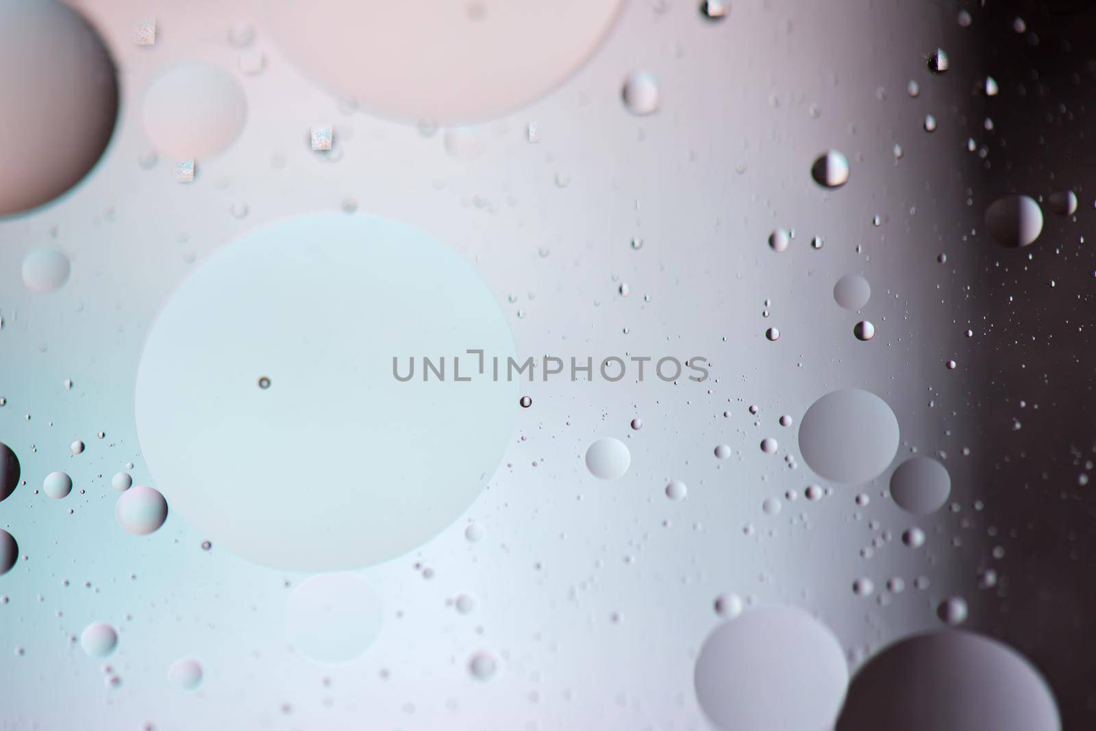 Defocused pastel and dark colored abstract background picture made with oil, water and soap by anytka