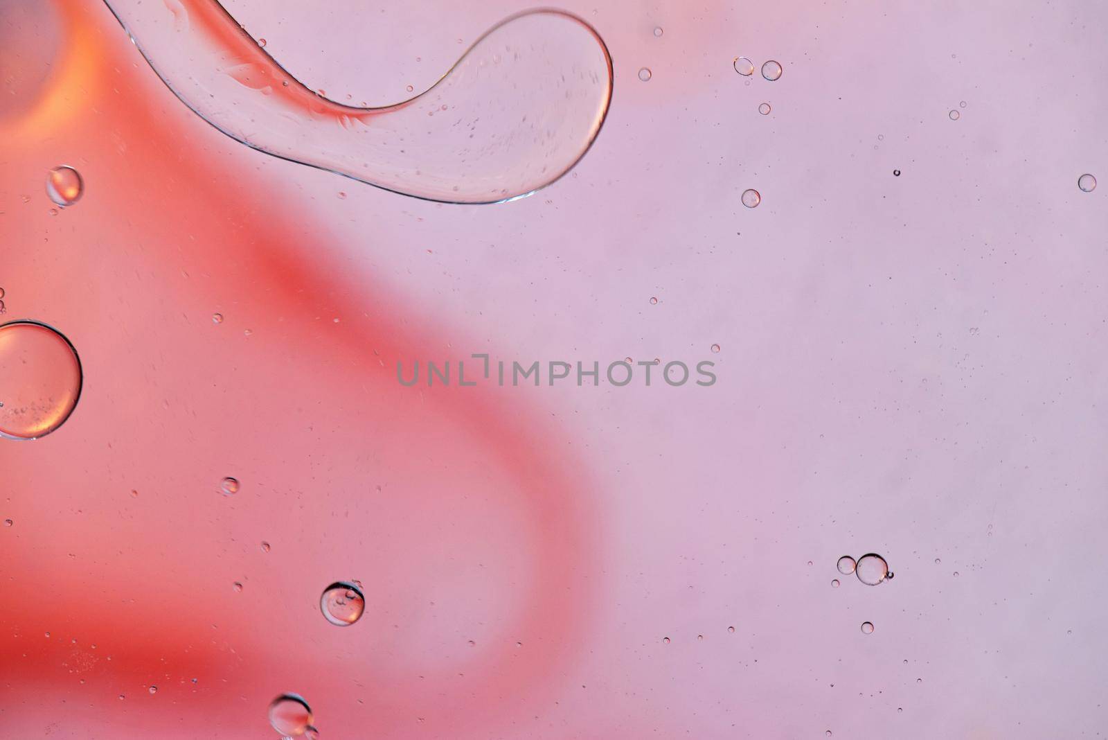Colorful abstract background with oil drops on water. Pink red color